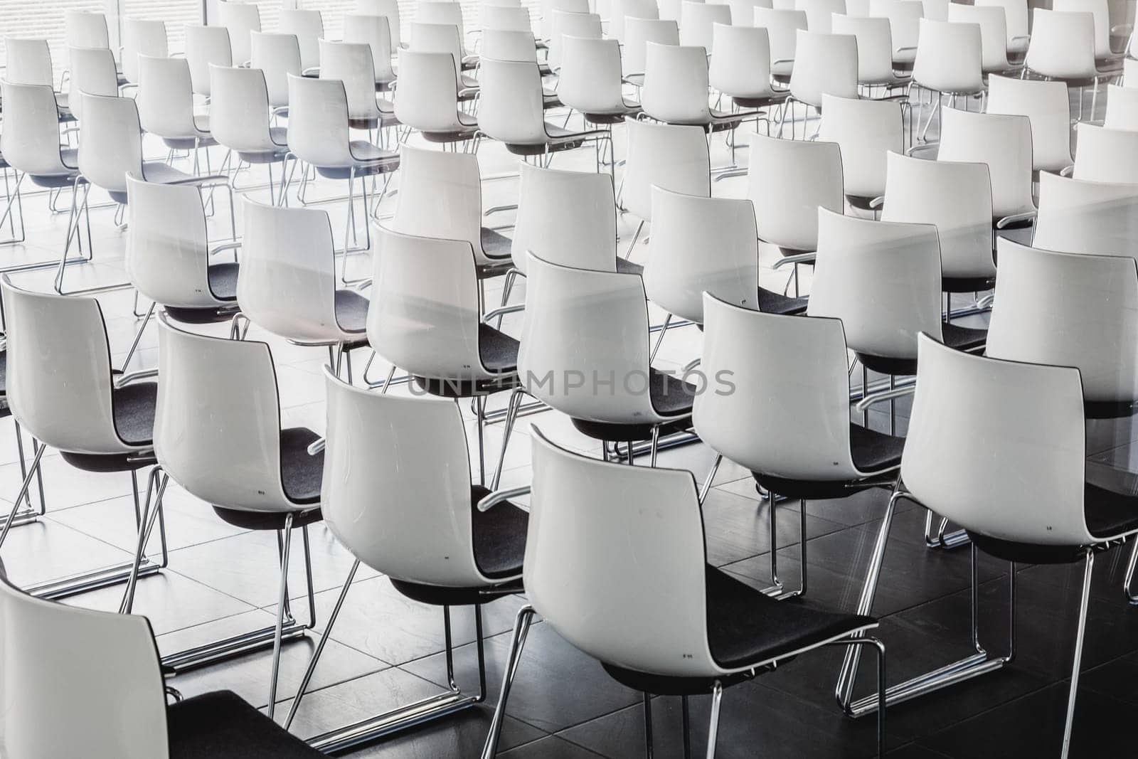 Interior of empty contemporary conference hall with white chairs.