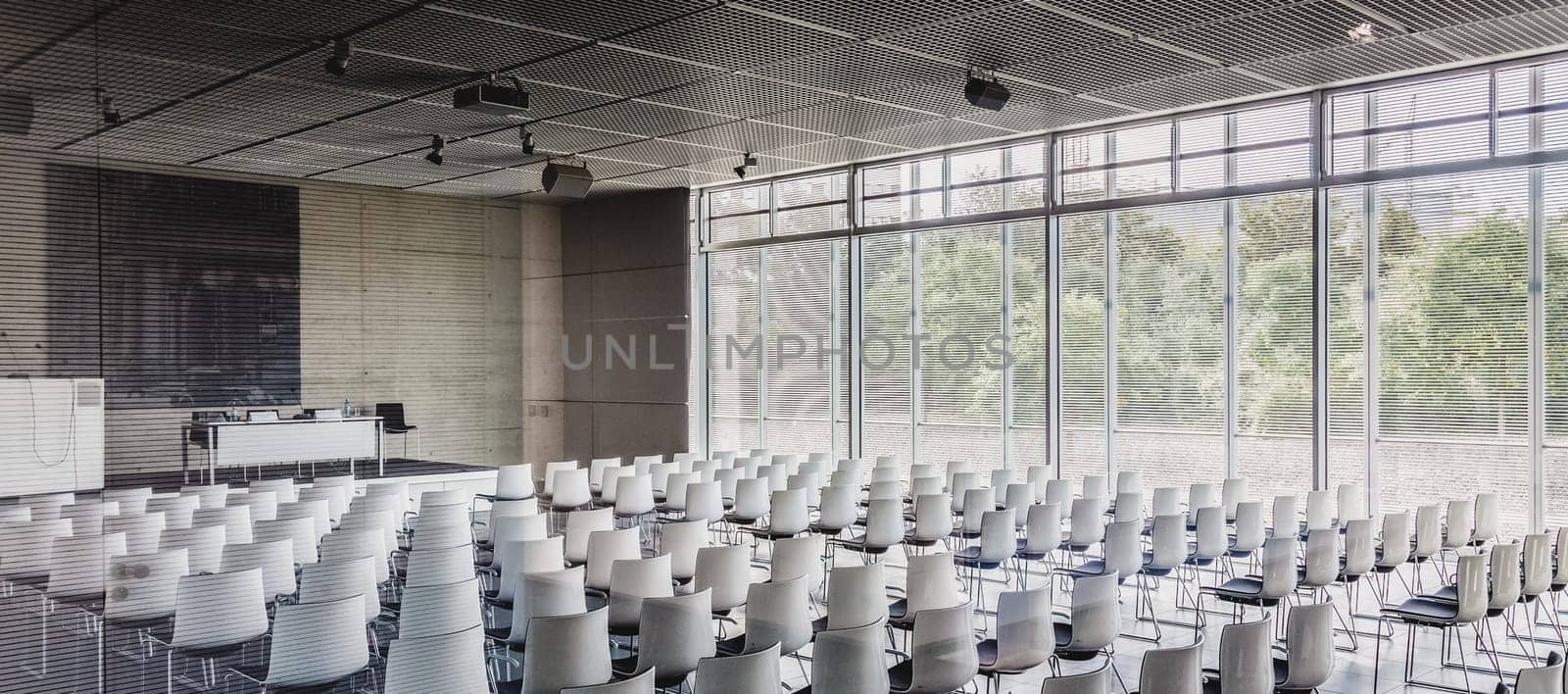 Interior of empty contemporary conference hall with white chairs.