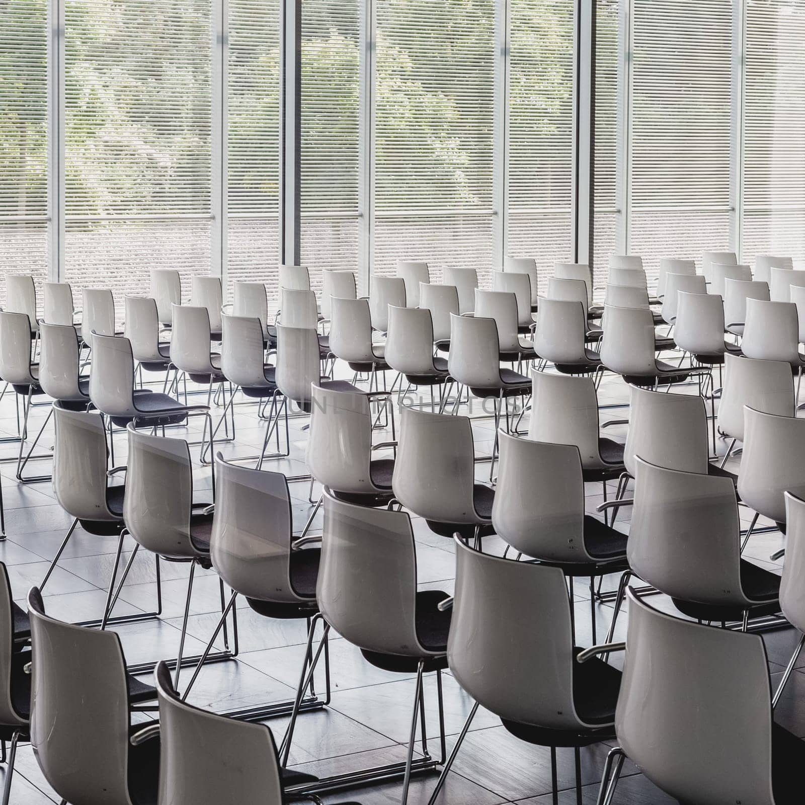 Interior of empty contemporary conference hall with white chairs.