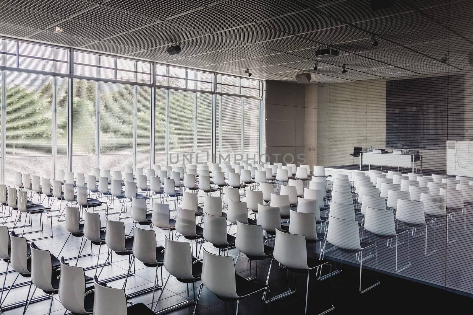 Interior of empty contemporary conference hall with white chairs.