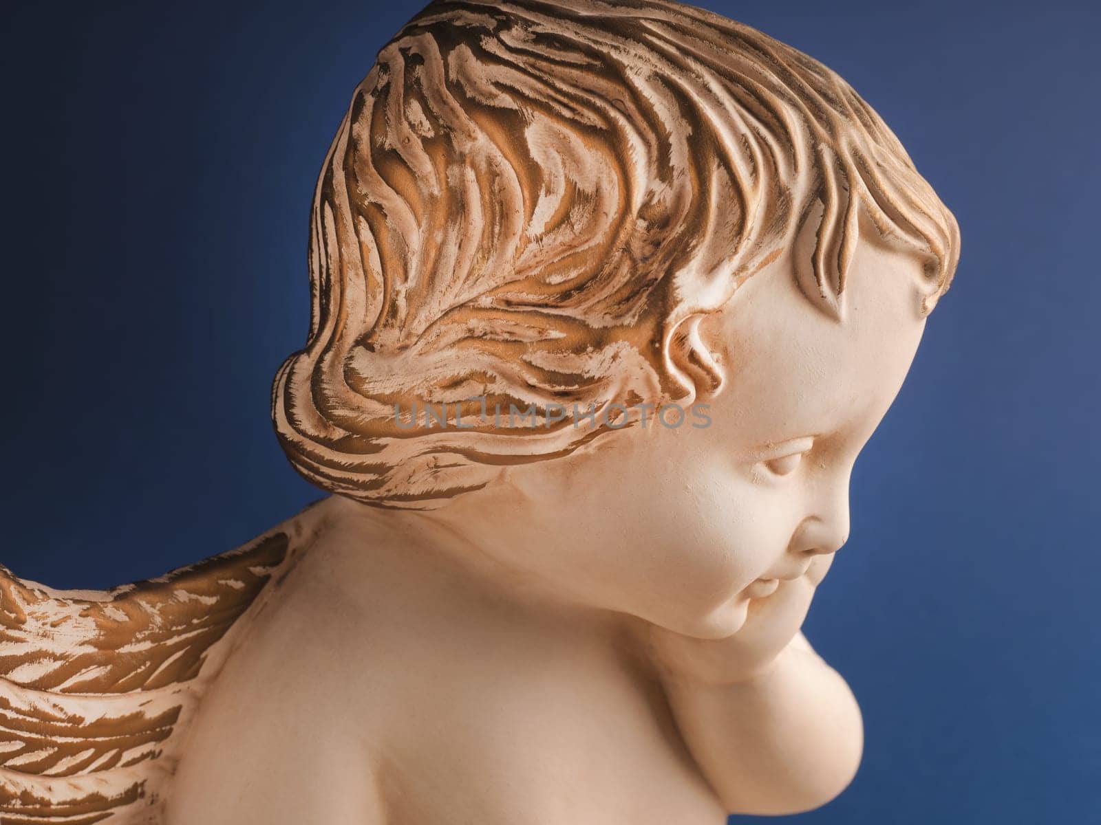 Close up of an angel with golden hair on a blue background, Christmas time