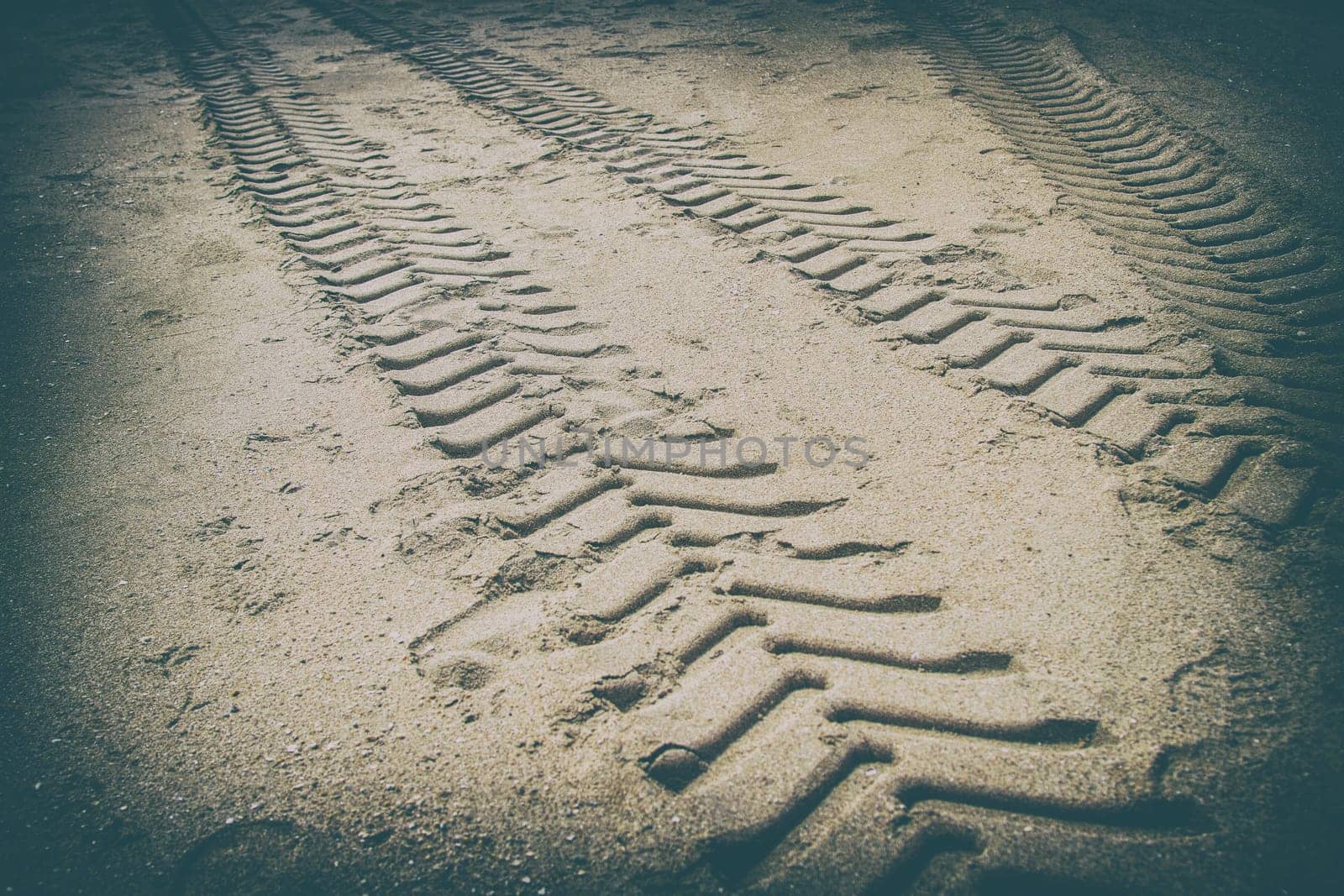 Car marks on the beach in black border