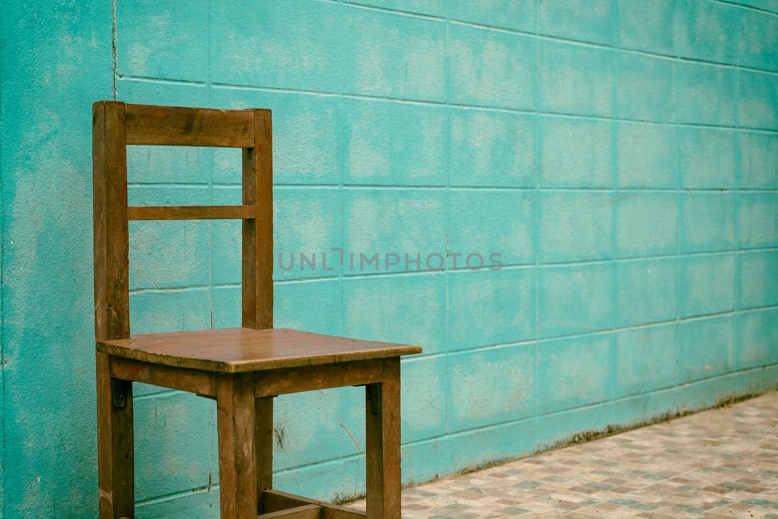 Wooden chair with blue concrete wall