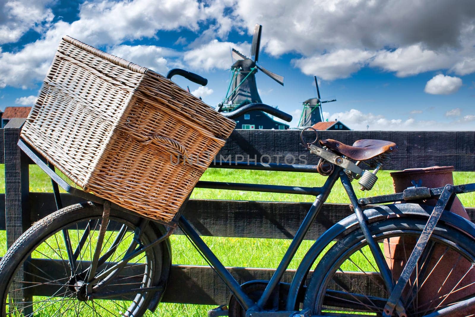 Bicycle with windmill and blue sky background. Scenic countryside landscape close to Amsterdam in Netherlands.