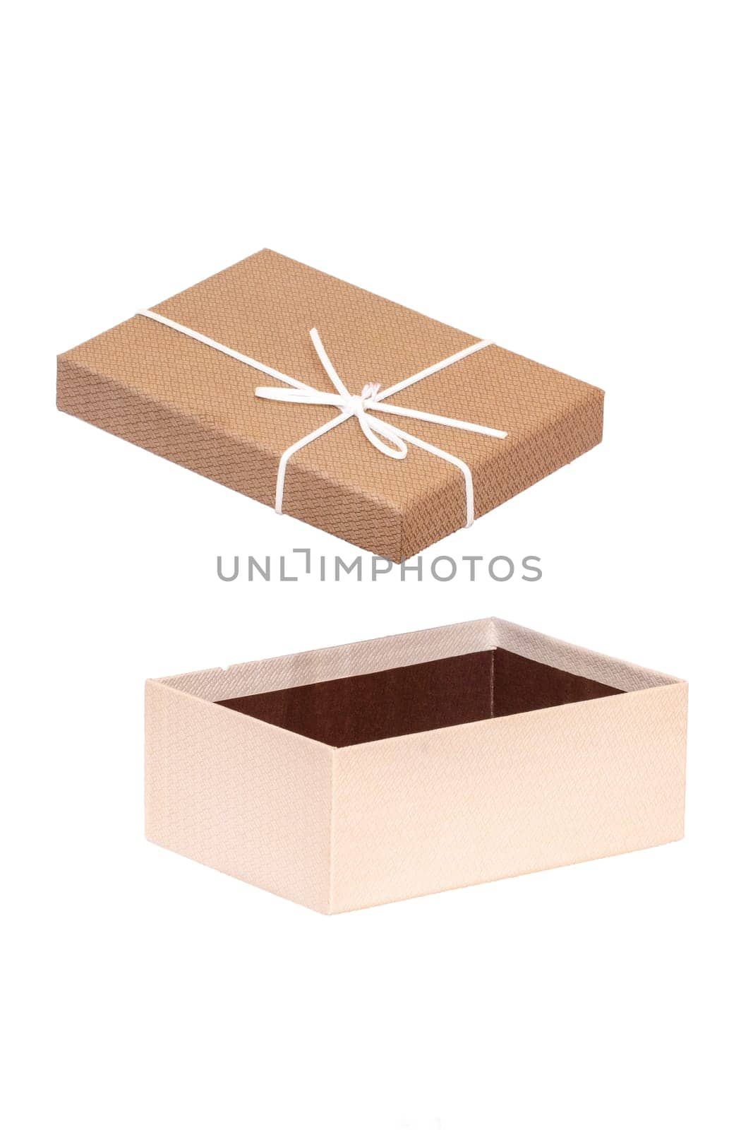 Decoration element isolated. Close-up of a brown white present or gift box with white ribbon bow isolated on a white background. Birthday, valentine, wedding or other holidays. Macro.
