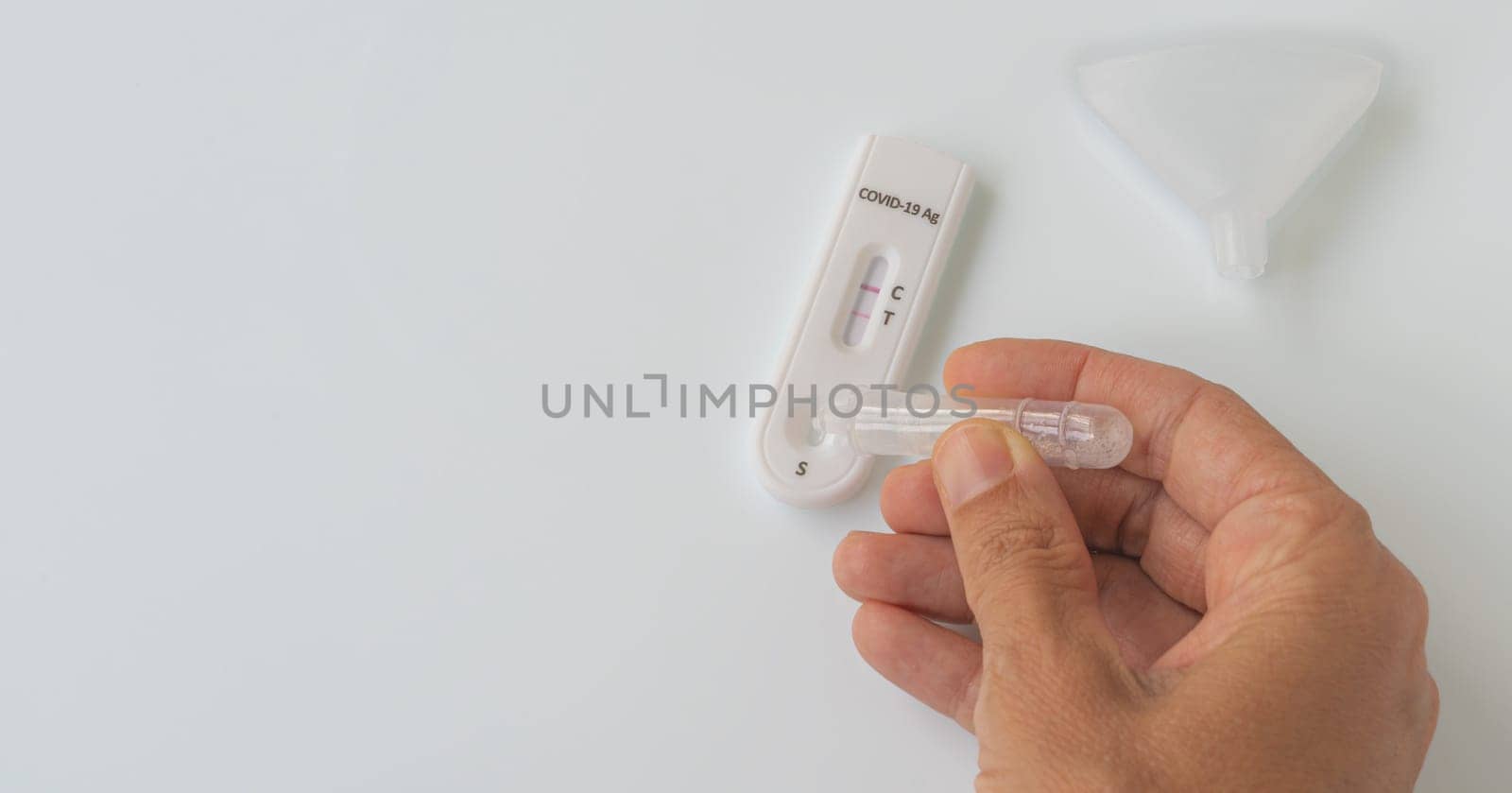 Making Coronavirus Covid-19 antigen test with positive result on white background.
