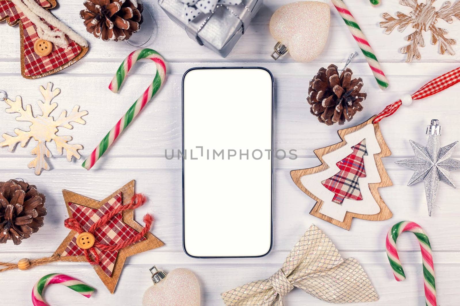 Smartphone mock up with rustic Christmas decorations on withe wood table for app presentation. View from above