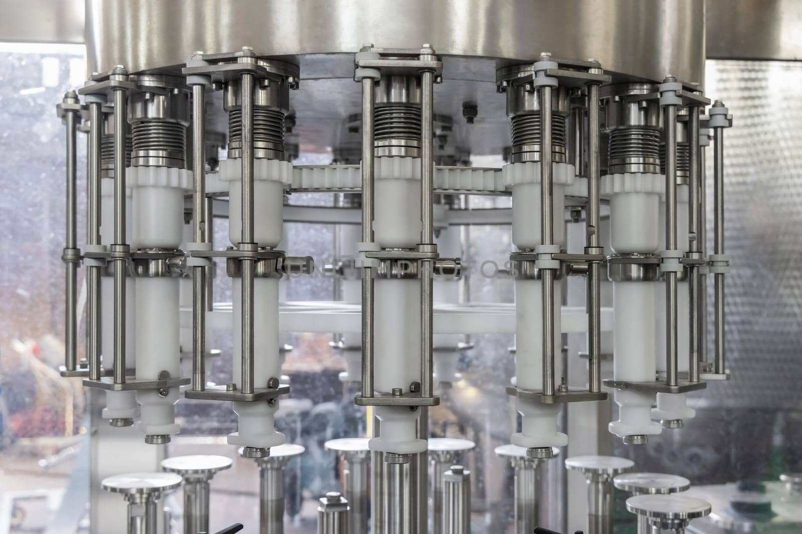 Industrial bottling machine at modern wine factory in Italy, close up. Automatic conveyor line for wine-producing