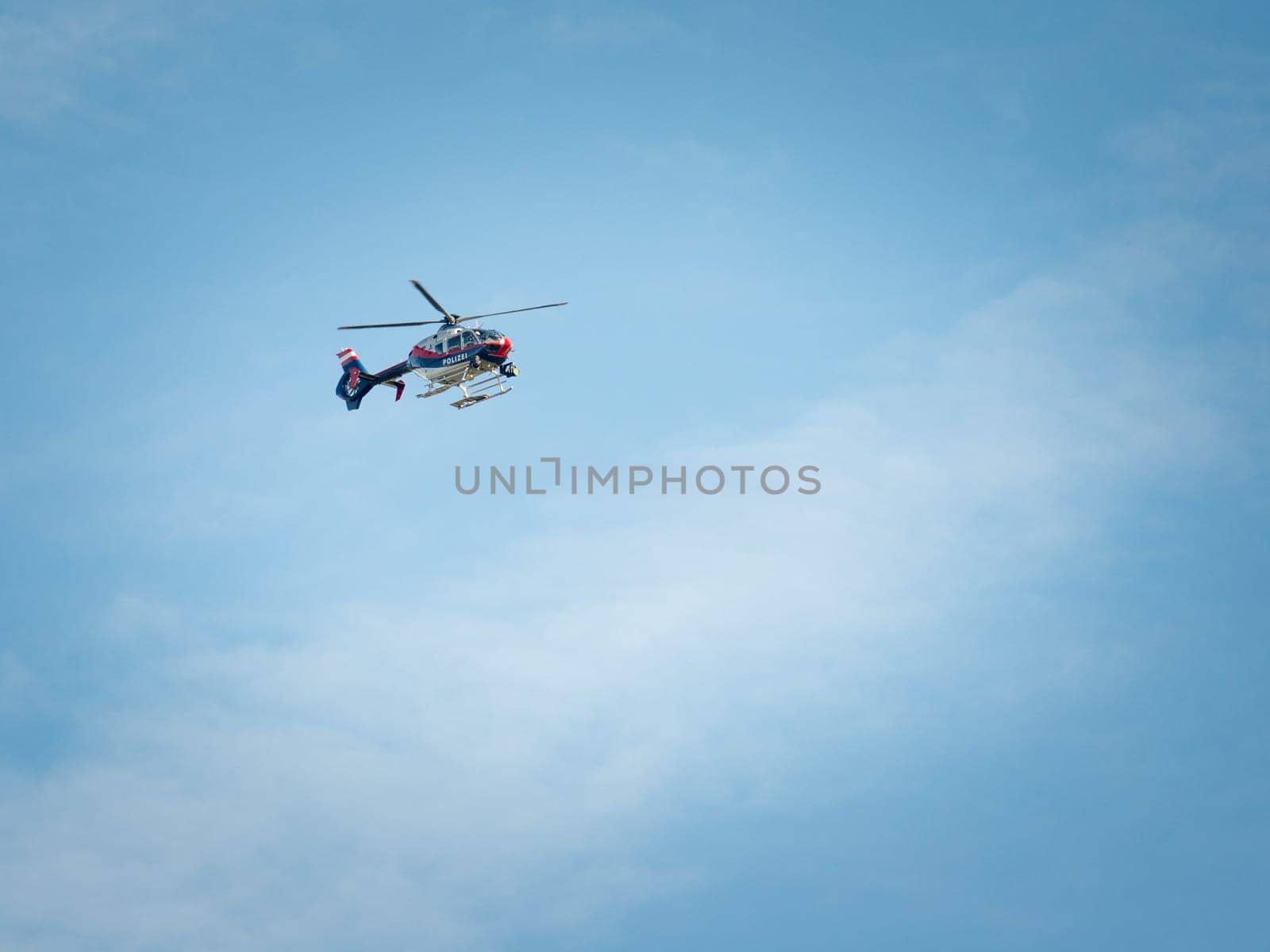 Police helicopter in flight speeding against the blue sky