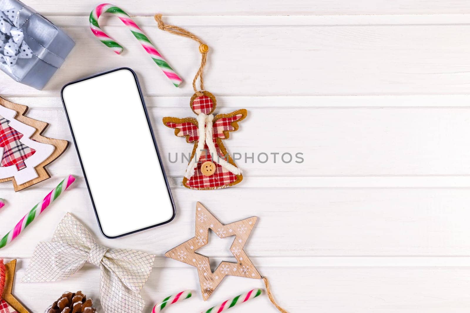 Smartphone mock up with rustic Christmas decorations on withe wood table for app presentation. View from above