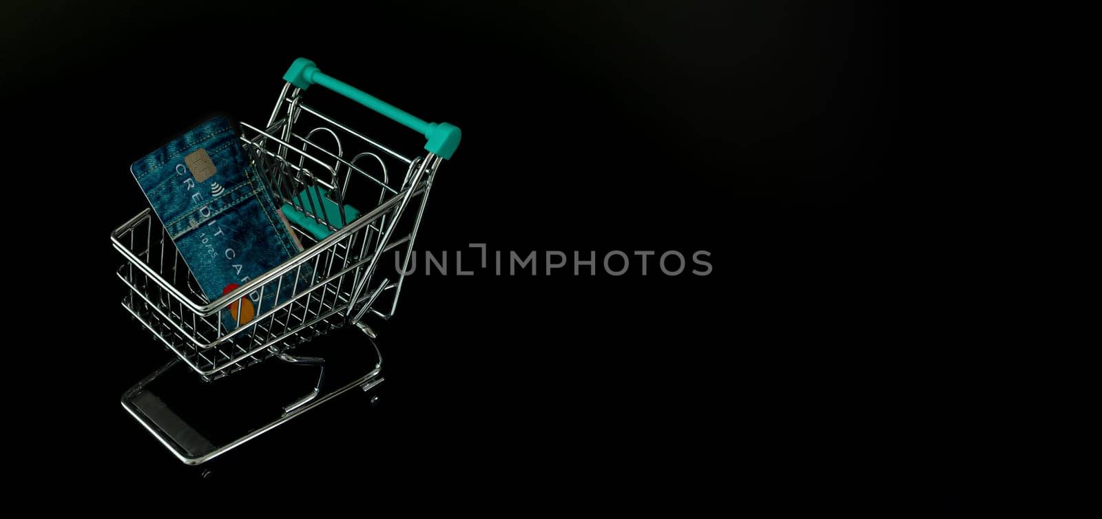 Black Friday advise with shopping trolley, credit card and black background.