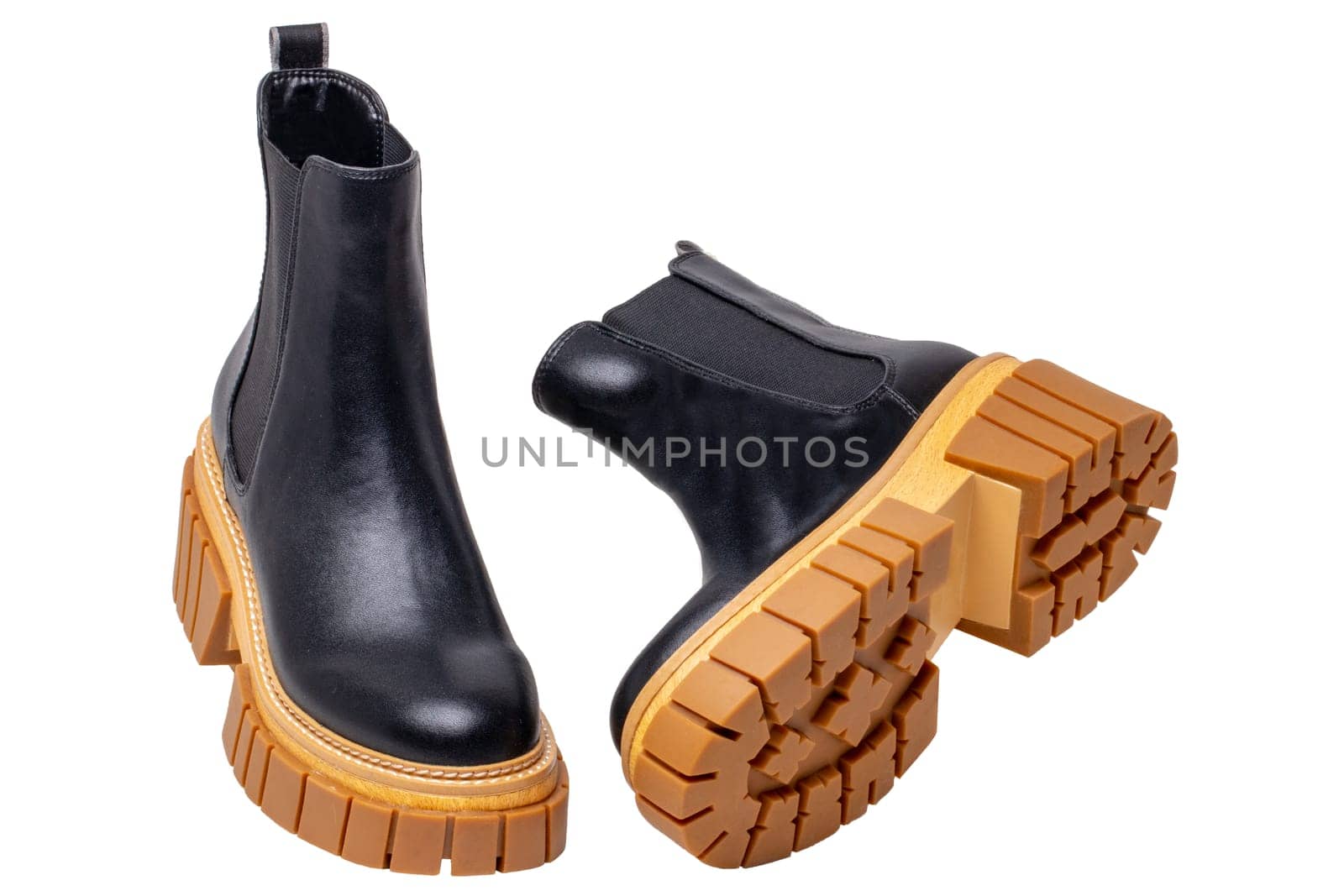 Ladies Chelsea boots. Close-up of a pair womens black leather chelsea boots with high heels isolated on a white background. Macro. Fashion advertisment shoes.