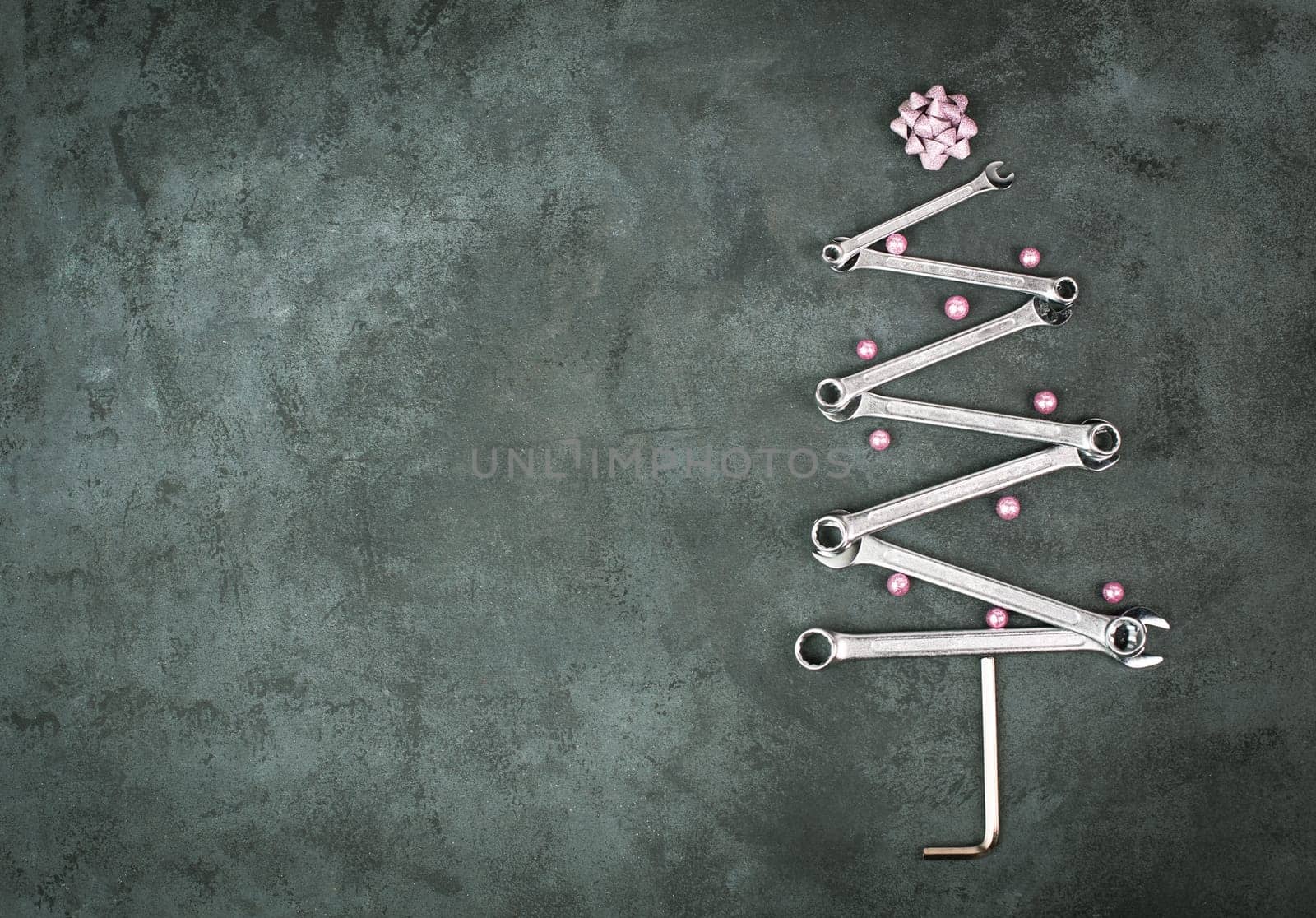 Christmas tree made with wrenches and baubels, new year greeting card with repair tools, dark background