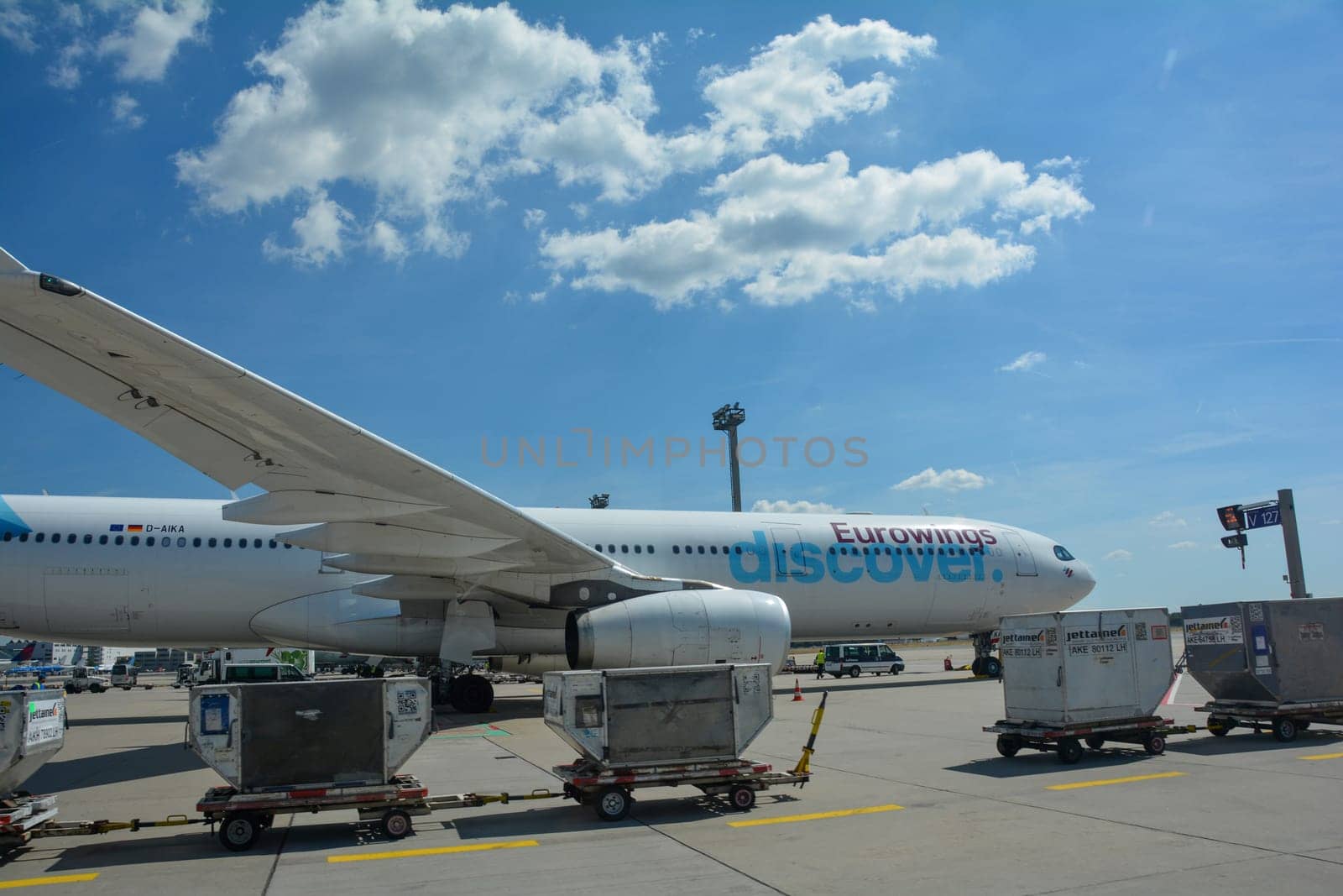 Frankfurt Airport Germany August 02, 2022 - Eurowings Discover airplane with luggage trolley and blue sky