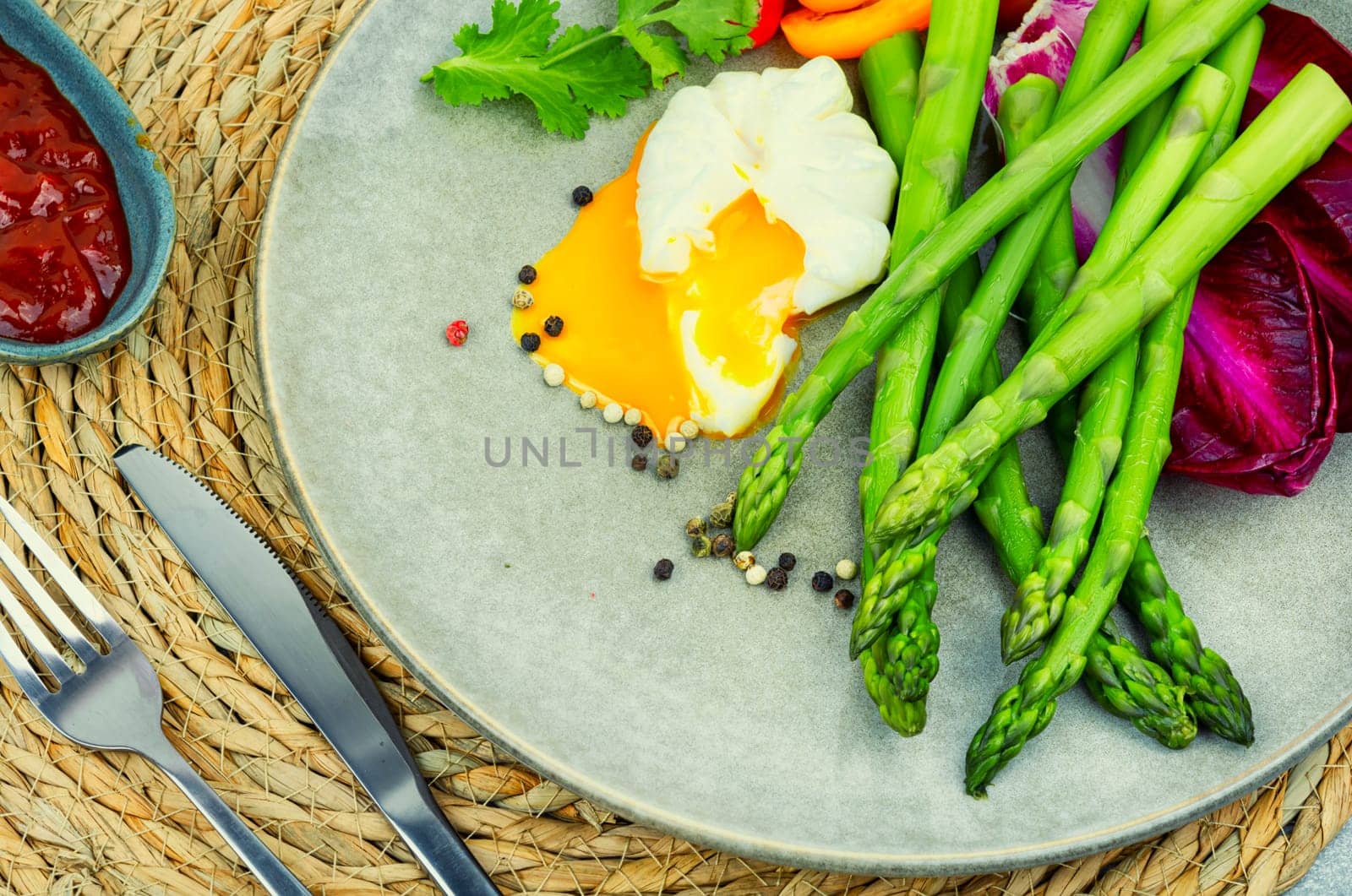 Diet salad with asparagus, poached egg and lettuce, tomato.