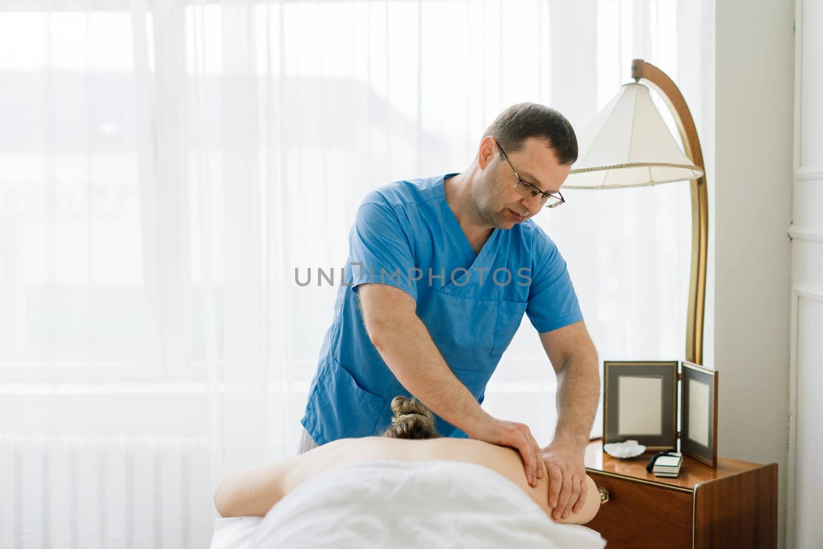 Young fat woman getting massage treatment in a day spa cabinet.