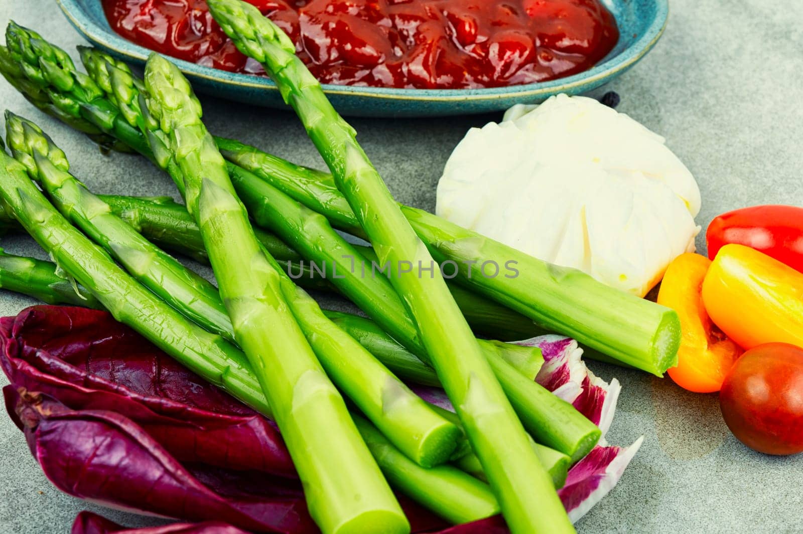 Appetizing salad with asparagus, lettuce, fresh tomatoes and poached egg. Healthy eating