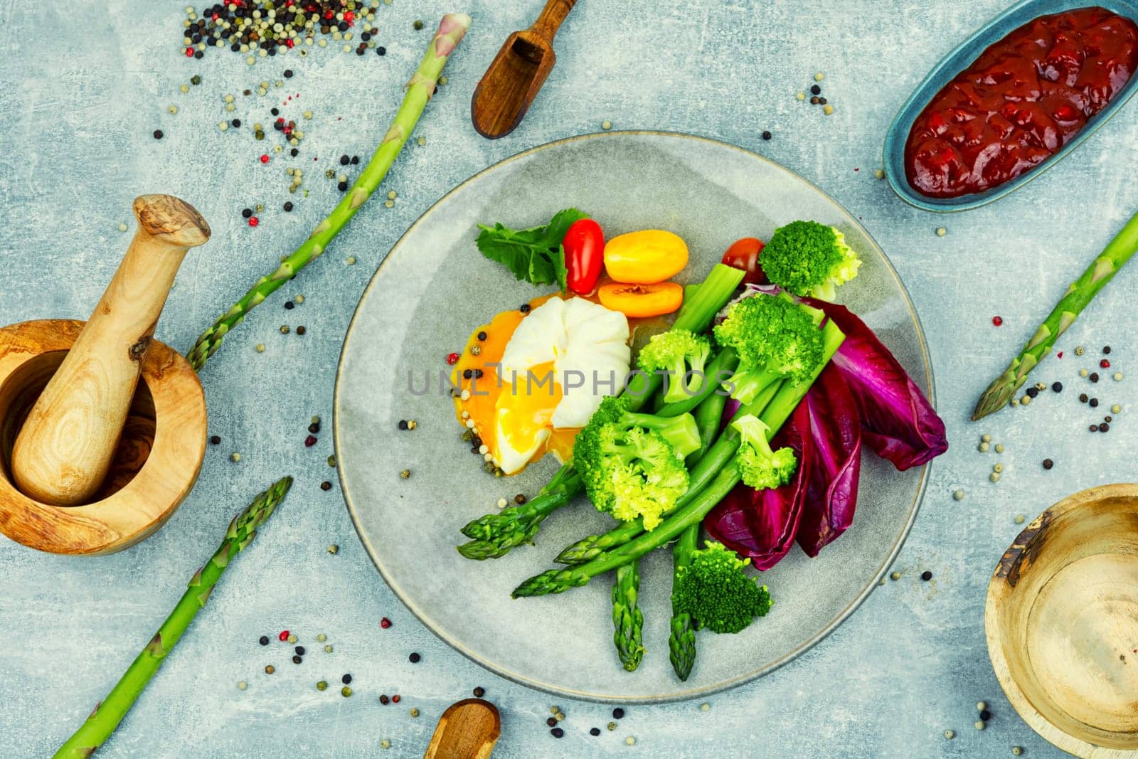 Appetizing salad with asparagus, lettuce, fresh tomatoes and poached egg. Healthy eating