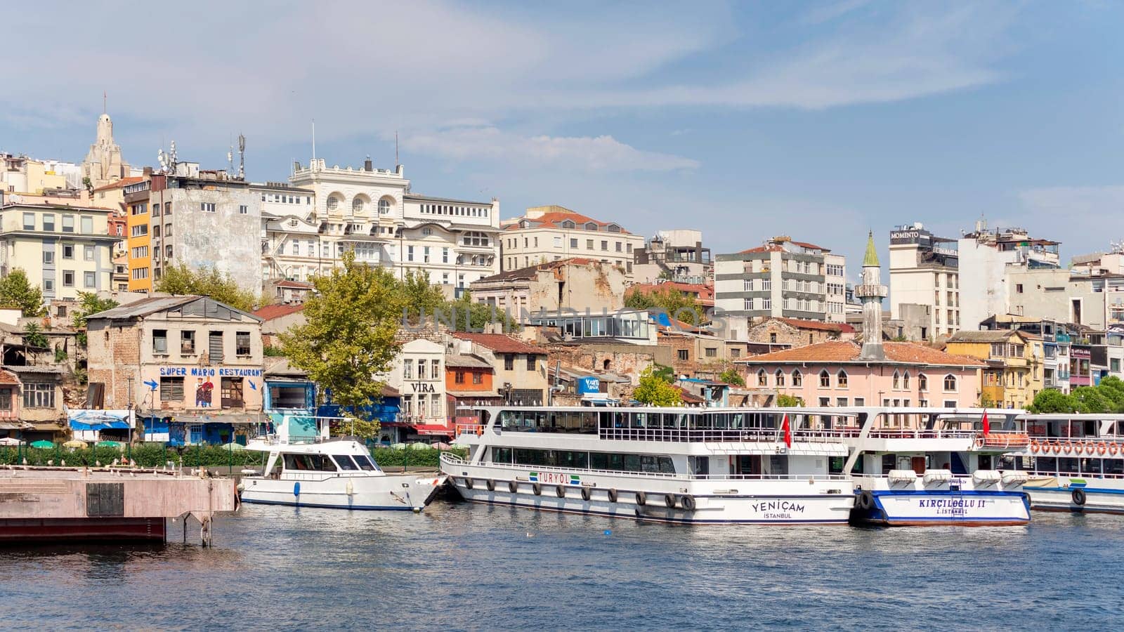 Istanbul city view from the sea of Golden Horn, with docked boats, in a summer sunny day