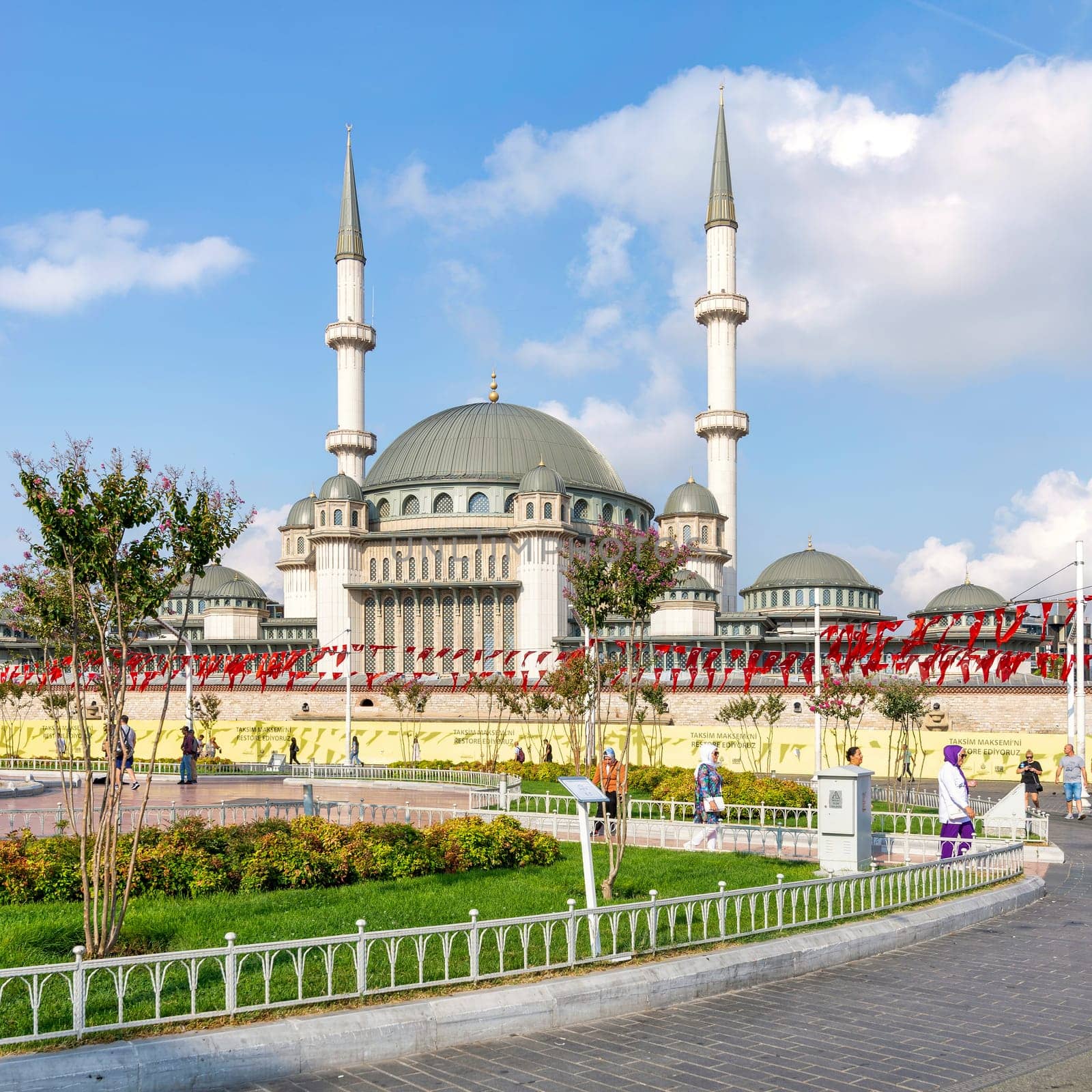 Istanbul, Turkey - September 2 2022: Pedestrians walking in front of Taksim Mosque, at Taksim Square, Beyoglu district, central Istanbul, in a sunny summer day