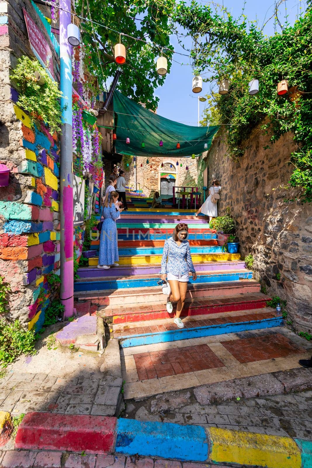 Istanbul, Turkey - August 28 2022: Tourists visiting famous traditional cafe decorated with multicolored panels and colorful stairs, suited in Balat District