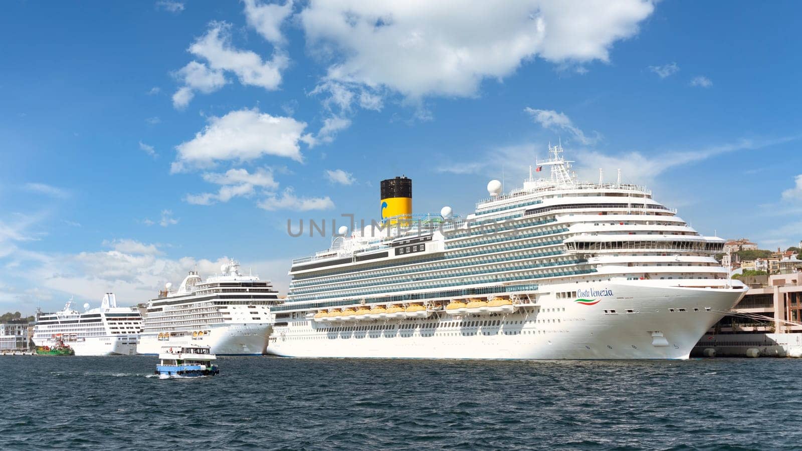 Three huge cruise ships docked at terminal of Galataport, located along shore of Bosphorus strait, in Karakoy neighbourhood, with Galata tower in the background, Istanbul, Turkey