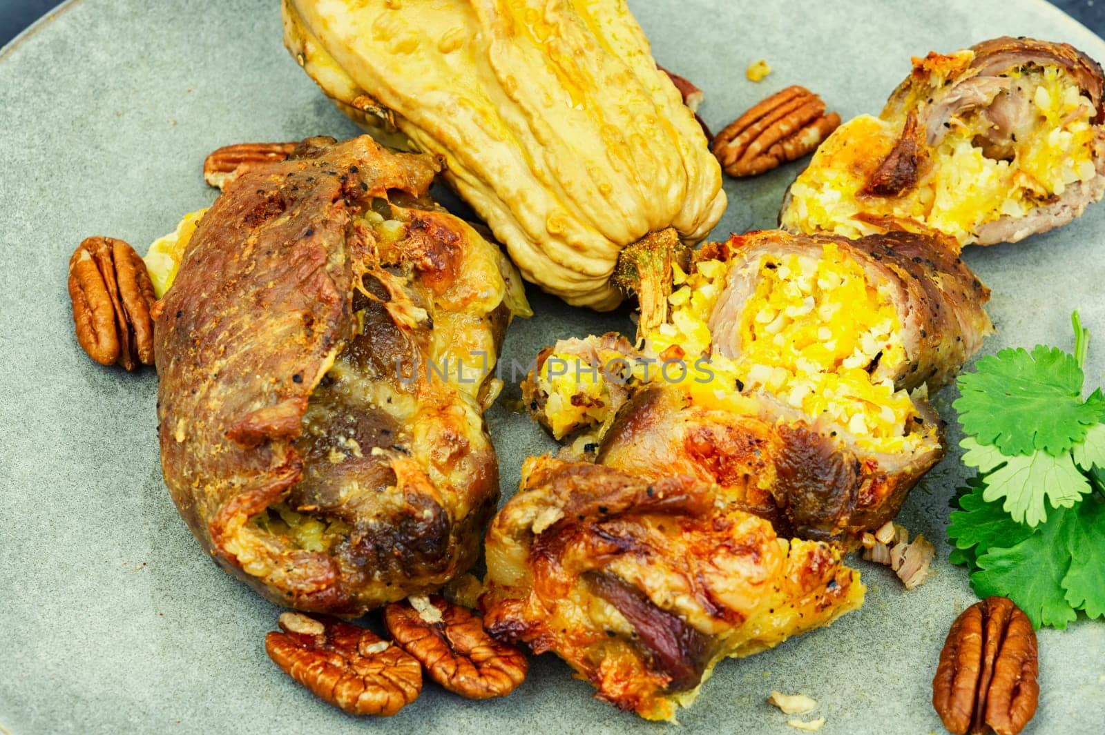 Tasty baked meat roulade stuffed with pumpkin in the oven dish. Autumn recipe.