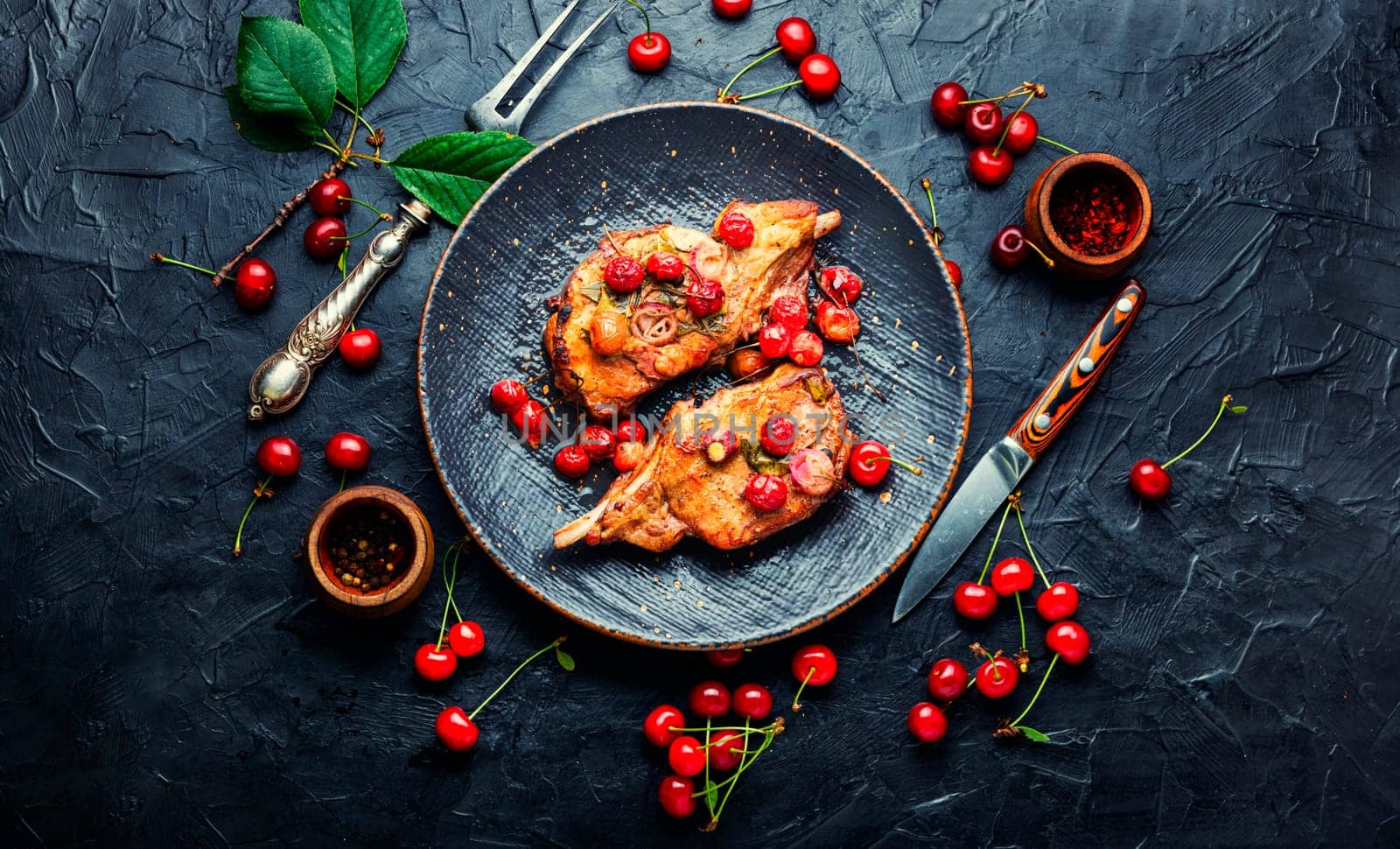 Tasty steaks prepared in a cherry marinade. Grilled meat on rib in berry sauce