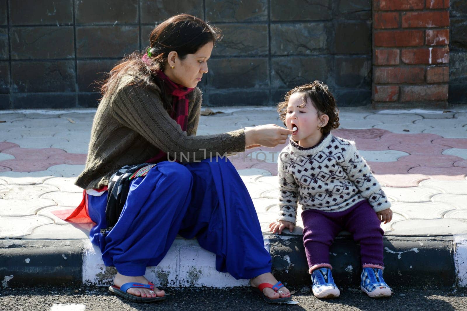 Mother and daughter eating ice cream outdoors