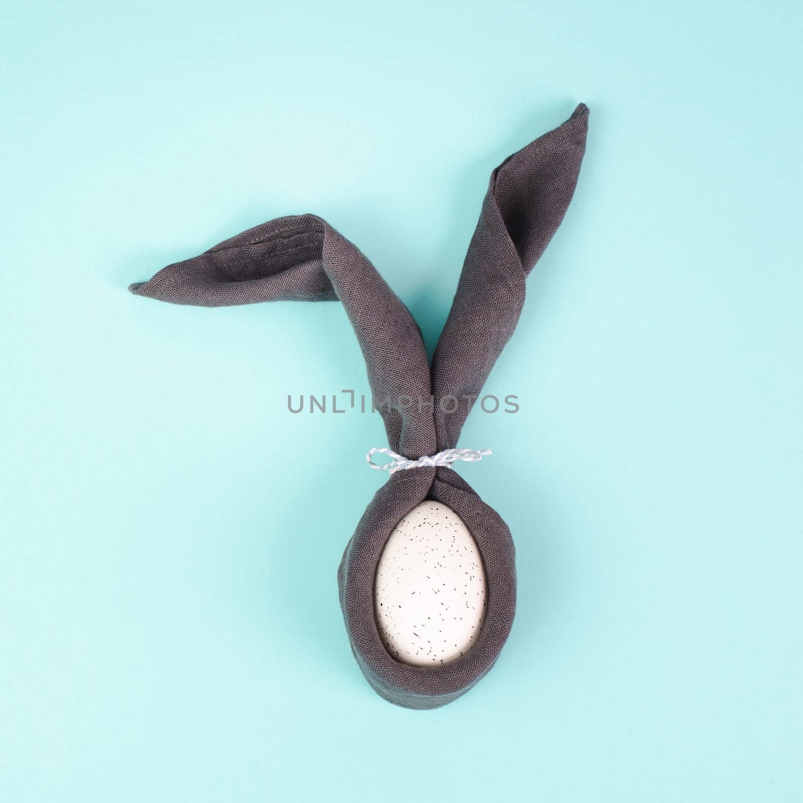 Easter bunny, wrapped egg with a cloth, minimal spring holiday concept