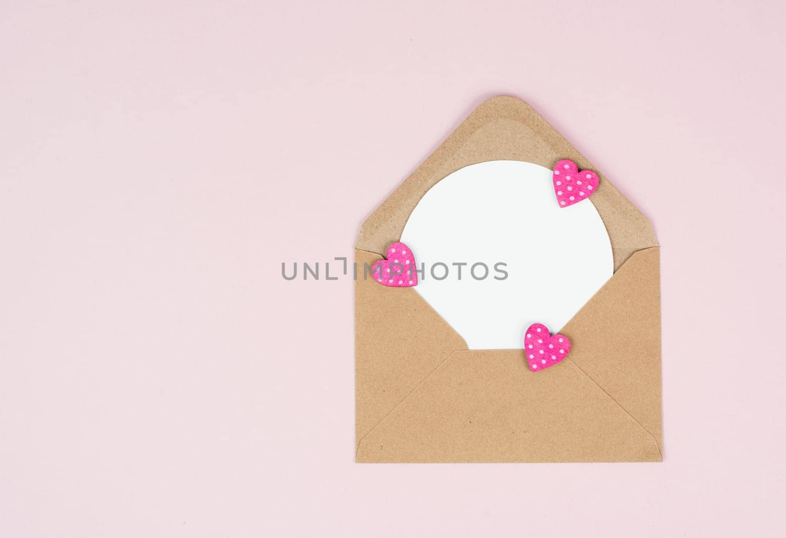 Valentine day greeting card, envelope with hearts on pastel background, love symbol, flat lay
