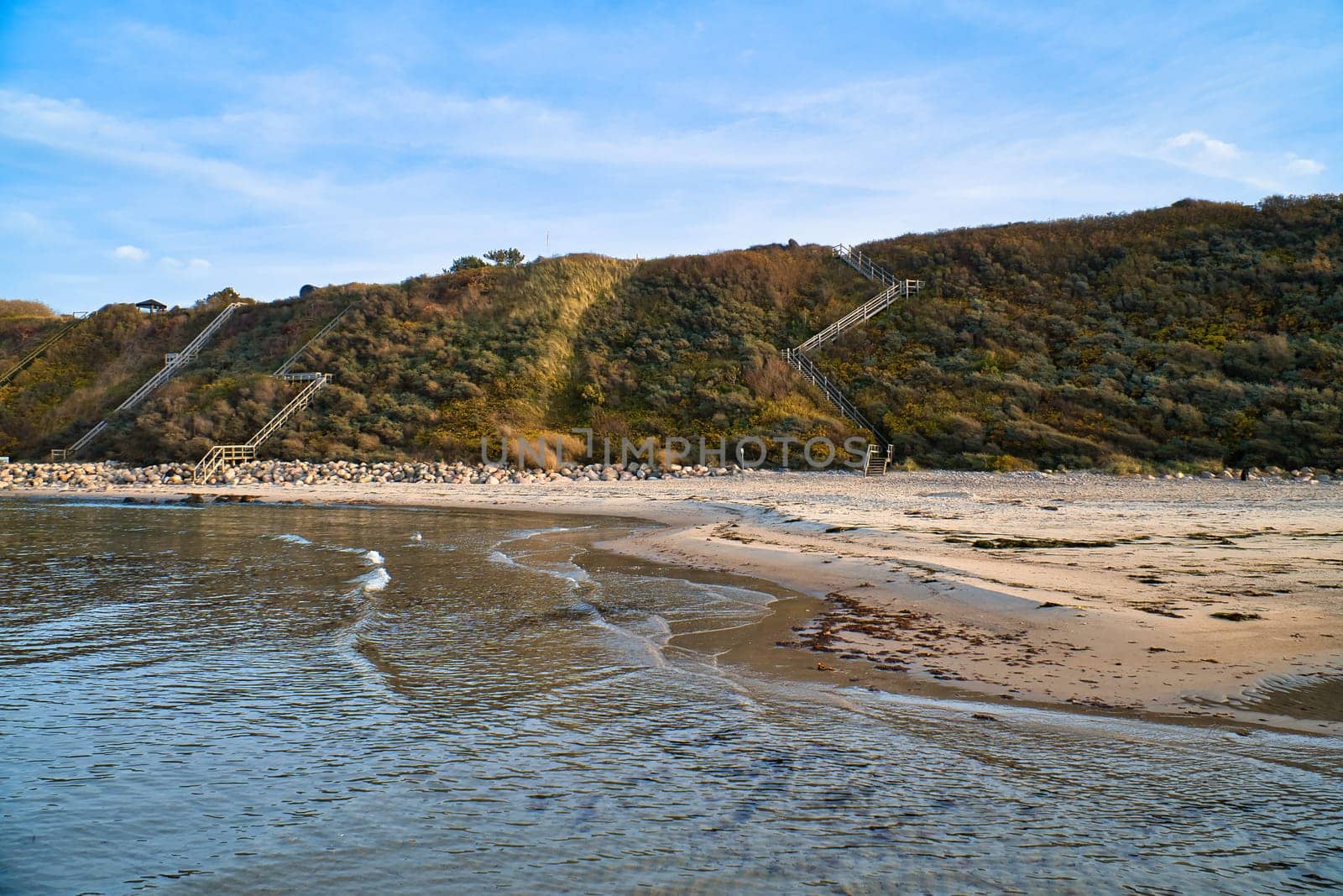 Coastal landscape in Denmark with sandy beach and waves in the ocean. Ocean landscape photo