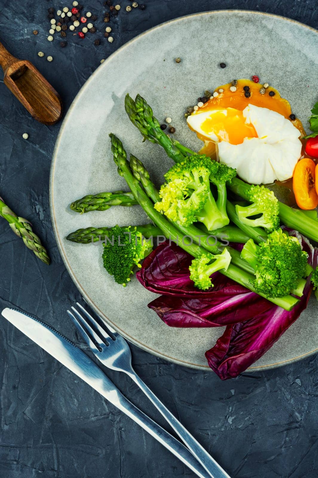 Delicious salad with asparagus, lettuce, broccoli and poached egg.