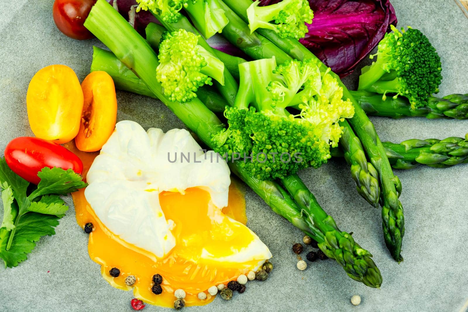 Delicious salad with asparagus, lettuce, broccoli and poached egg.