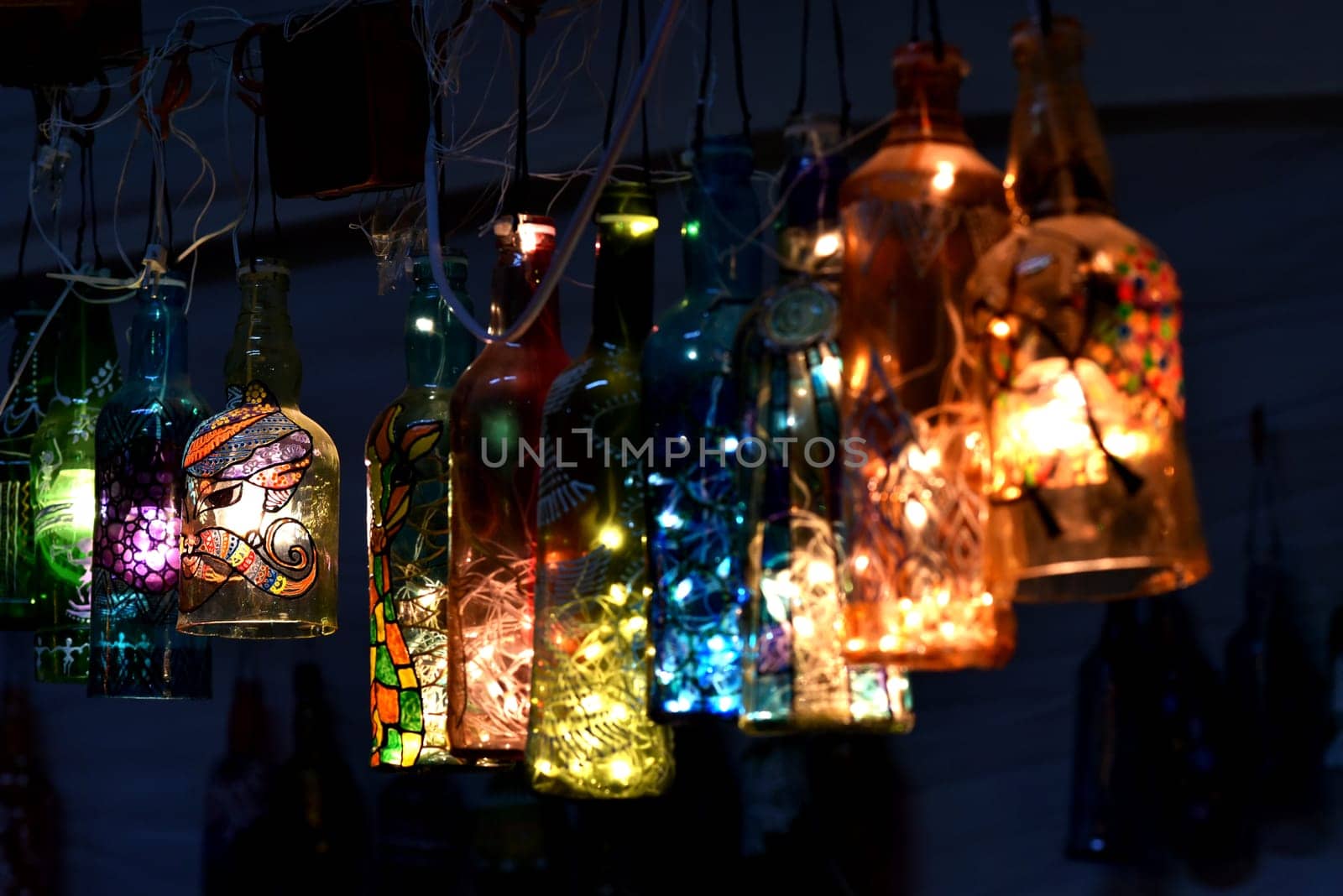 Hanging lights made out of discarded bottles. Home decor with painted bottle art and craft...