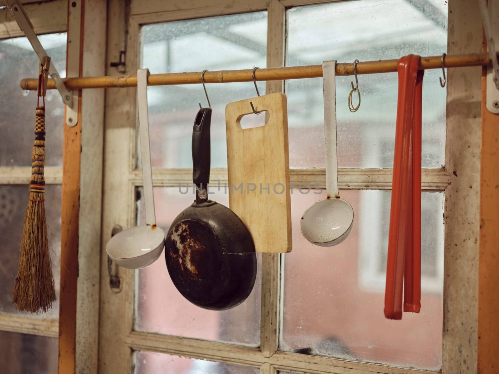 Old kitchen ware hanging on the bar. Different size of pans and kitchen ware on the wall, Home decoration, Kitchen background.