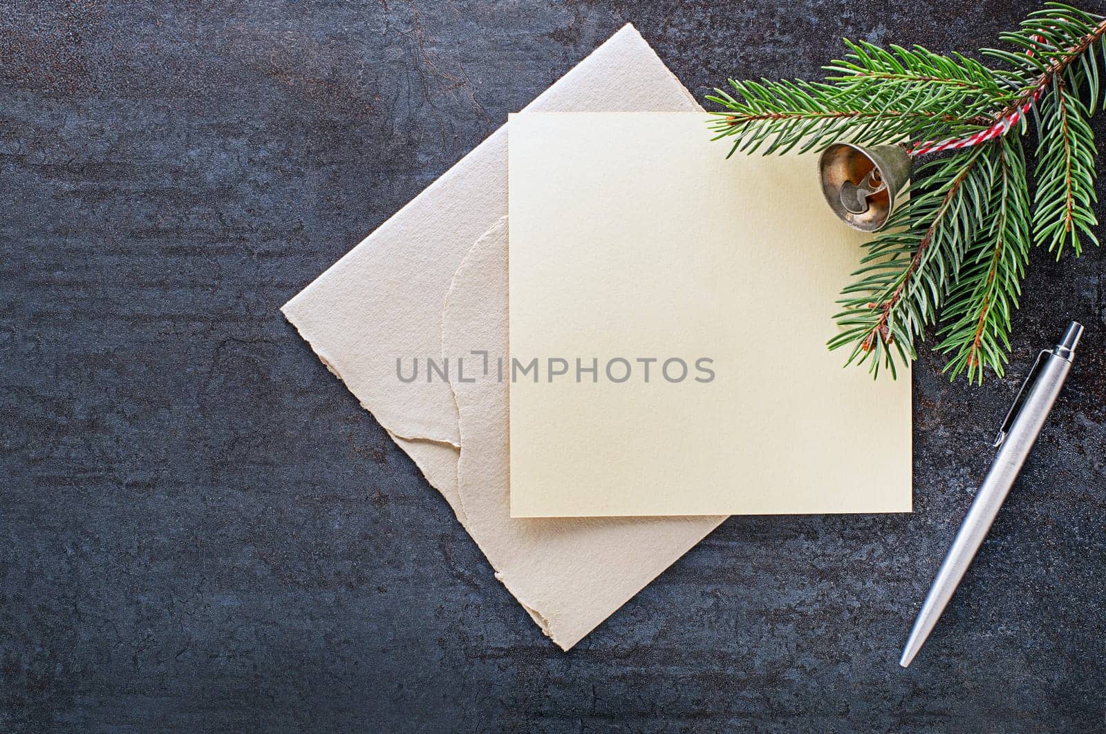 Christmas fir tree branch with paper card empty note and pen. Flat lay. Nature New Year holiday concept, top view, copy space
