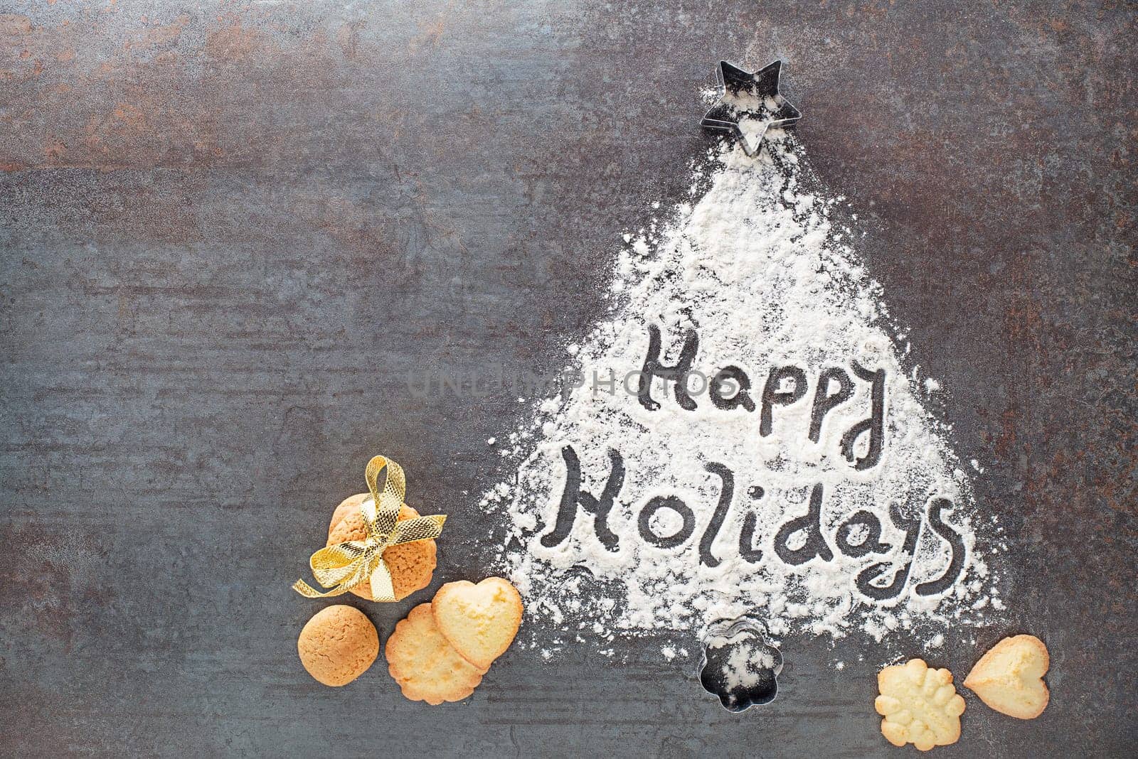 Happy Holidays written text made with flour decorations with cookies. Holidays, baking celebration background