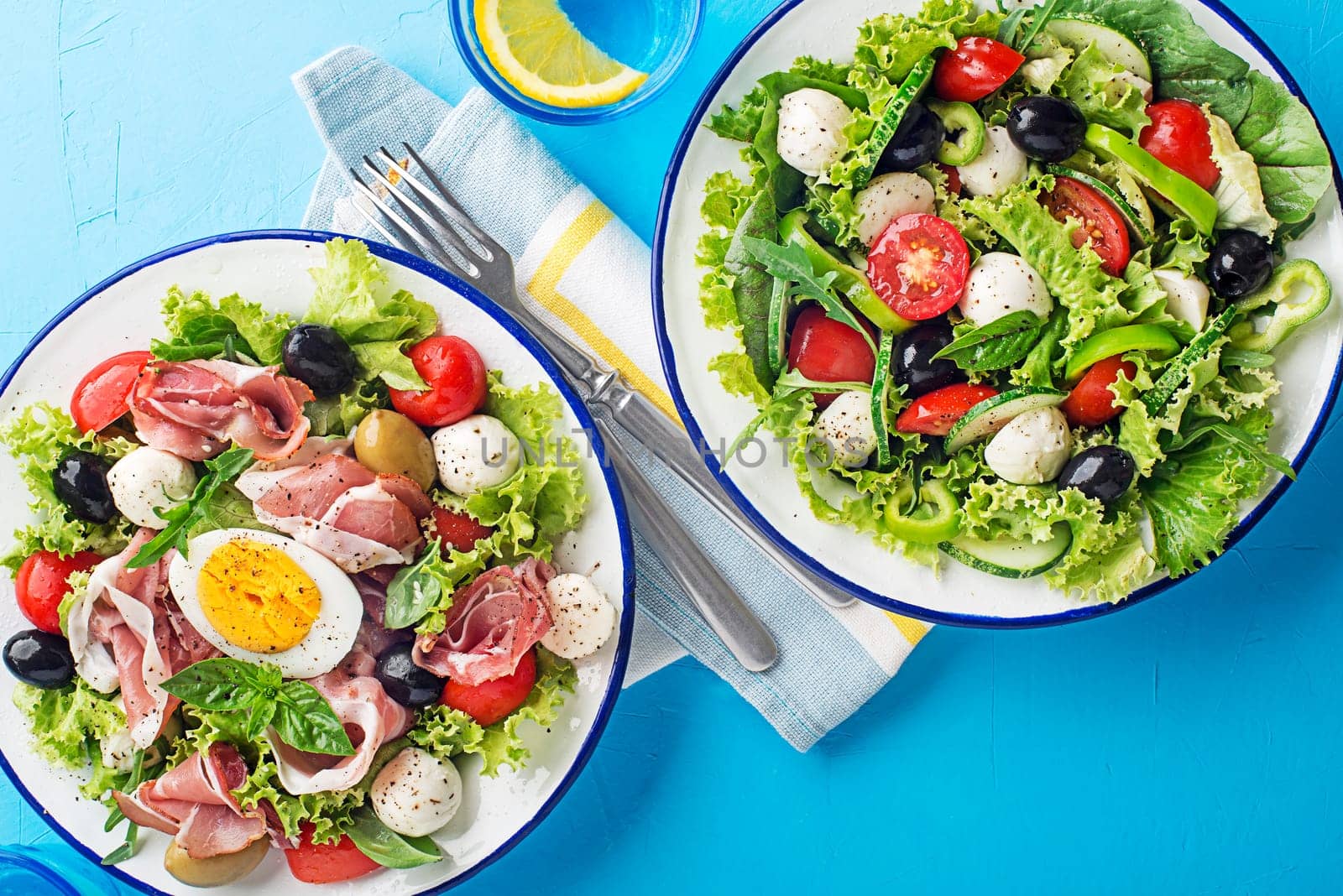 Healthy green salads with mixed healthy ingredients on blue table background