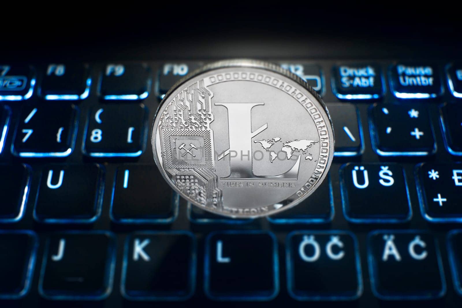 Lite coin on computer trading background. Virtual cryptocurrency concept.
