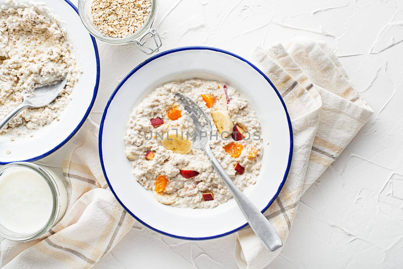 Oatmeal plate. A plate of oatmeal served with fresh fruit and milk. Healthy food, diet. Top view.