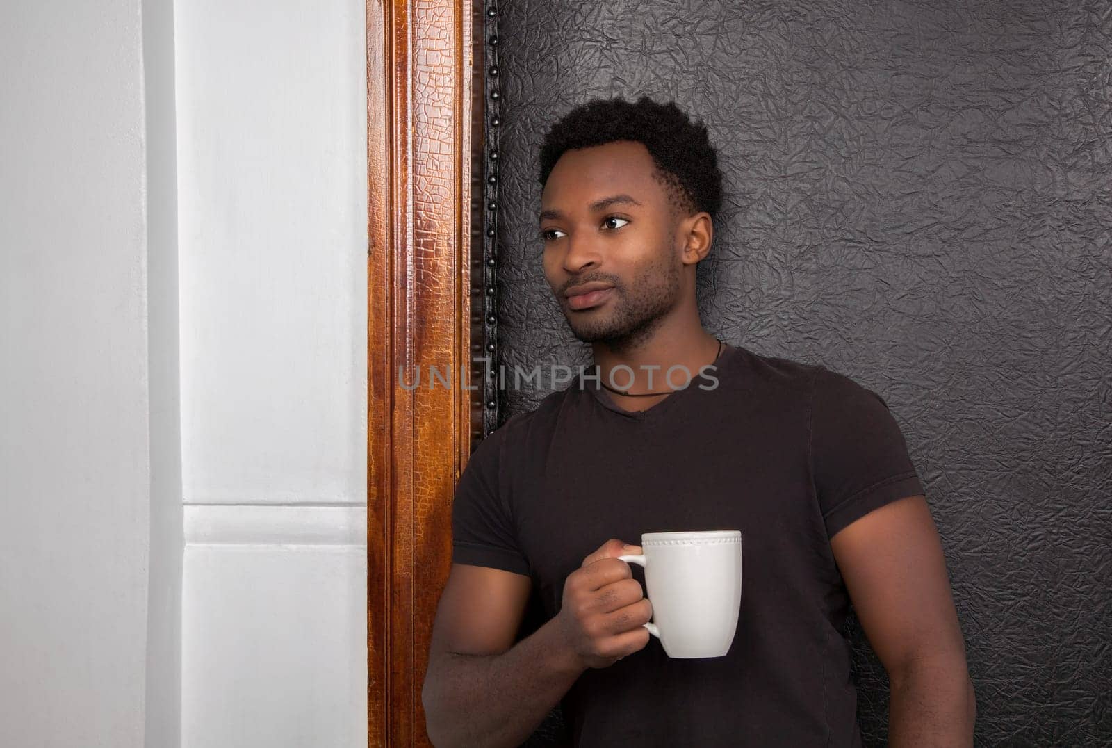 man drinking coffee leaning on door frame standing and dreaming relaxed owner