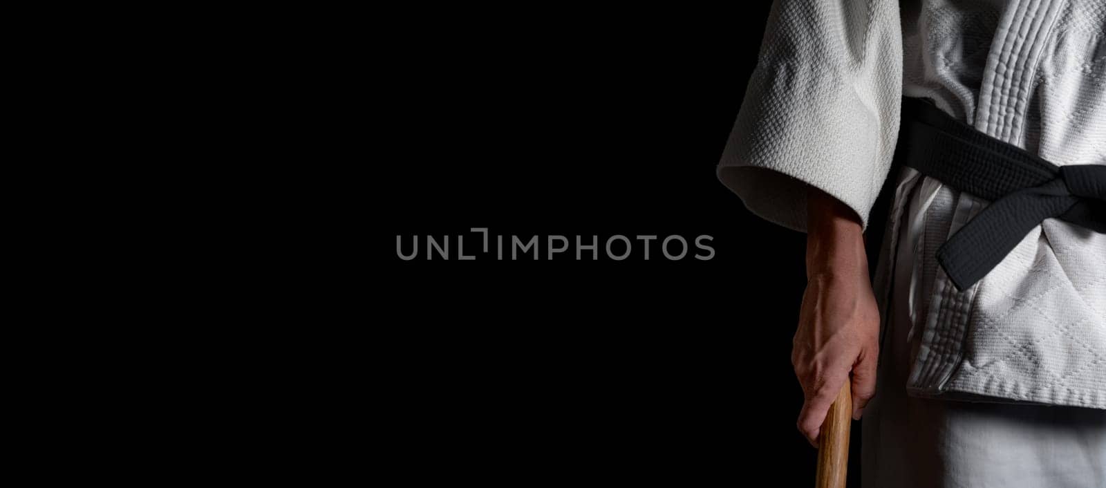 A person practicing aikido martial art on a black background.