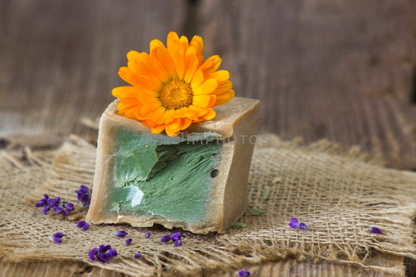 Natural handmade soap with calendula flower on rustic wooden background