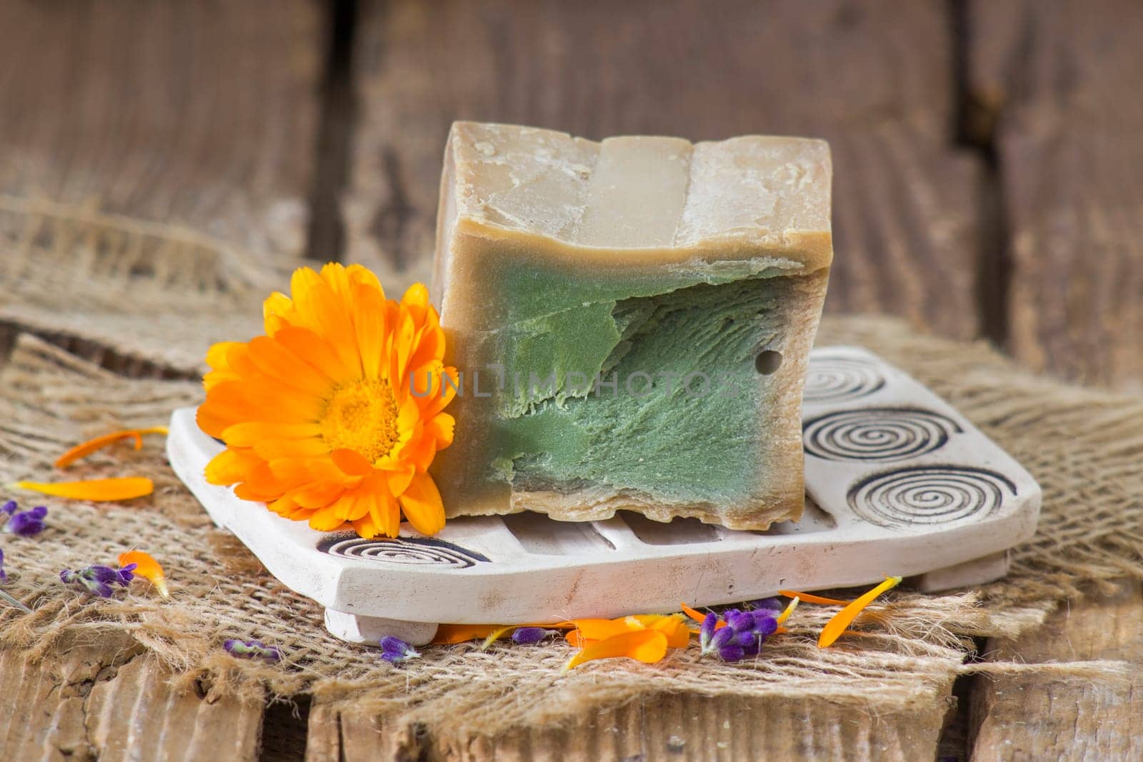 Natural handmade soap with calendula flower on rustic wooden background