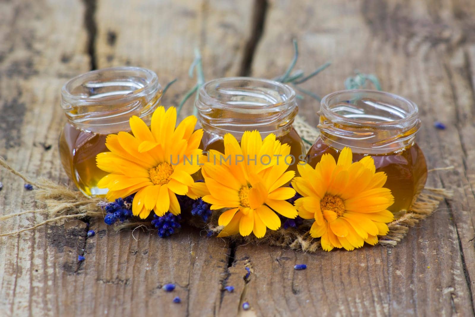 honey and calendula flowers on old wooden  background
