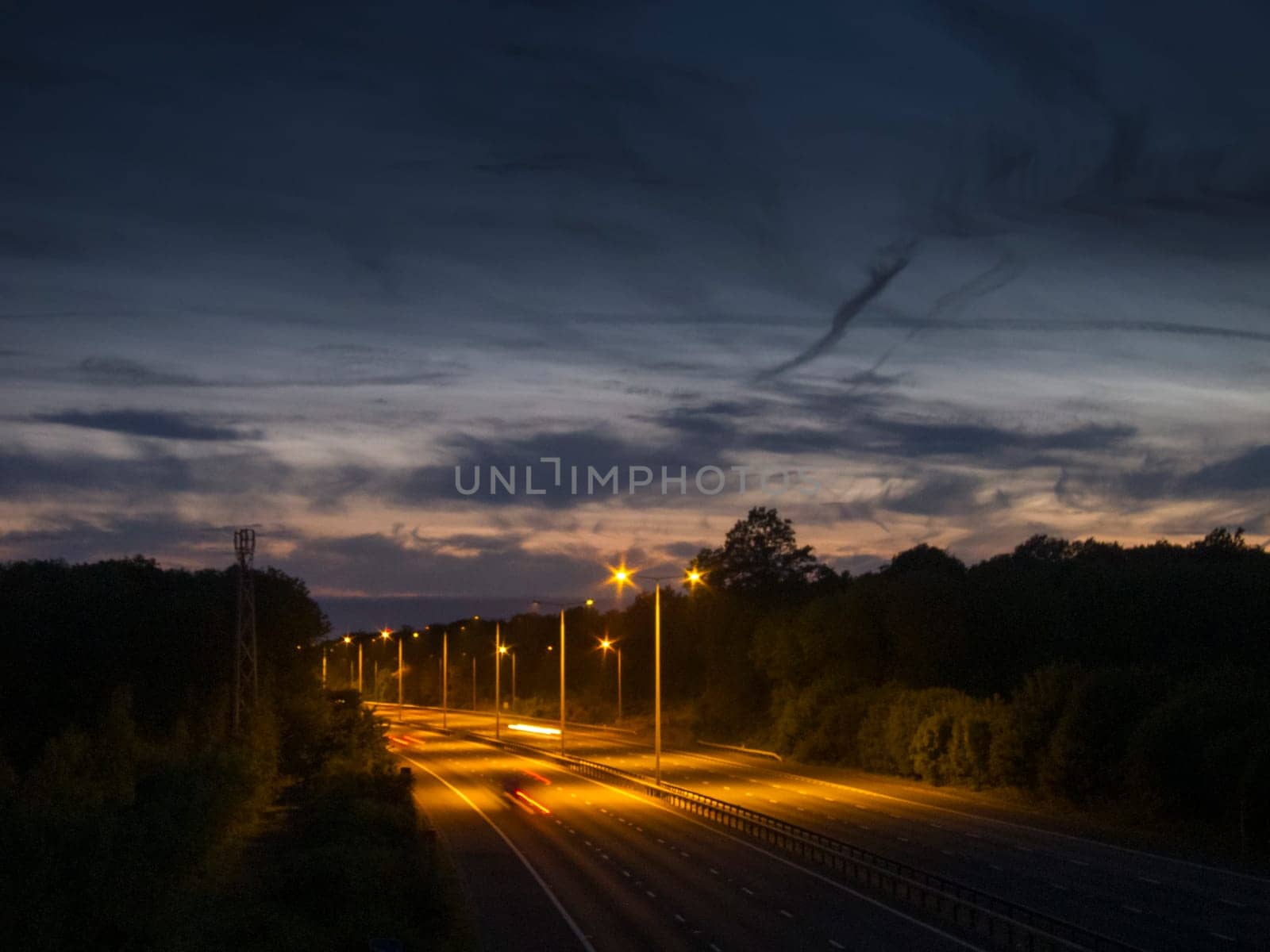 Light trails on the M20 motorway at dusk, Kent, UK
