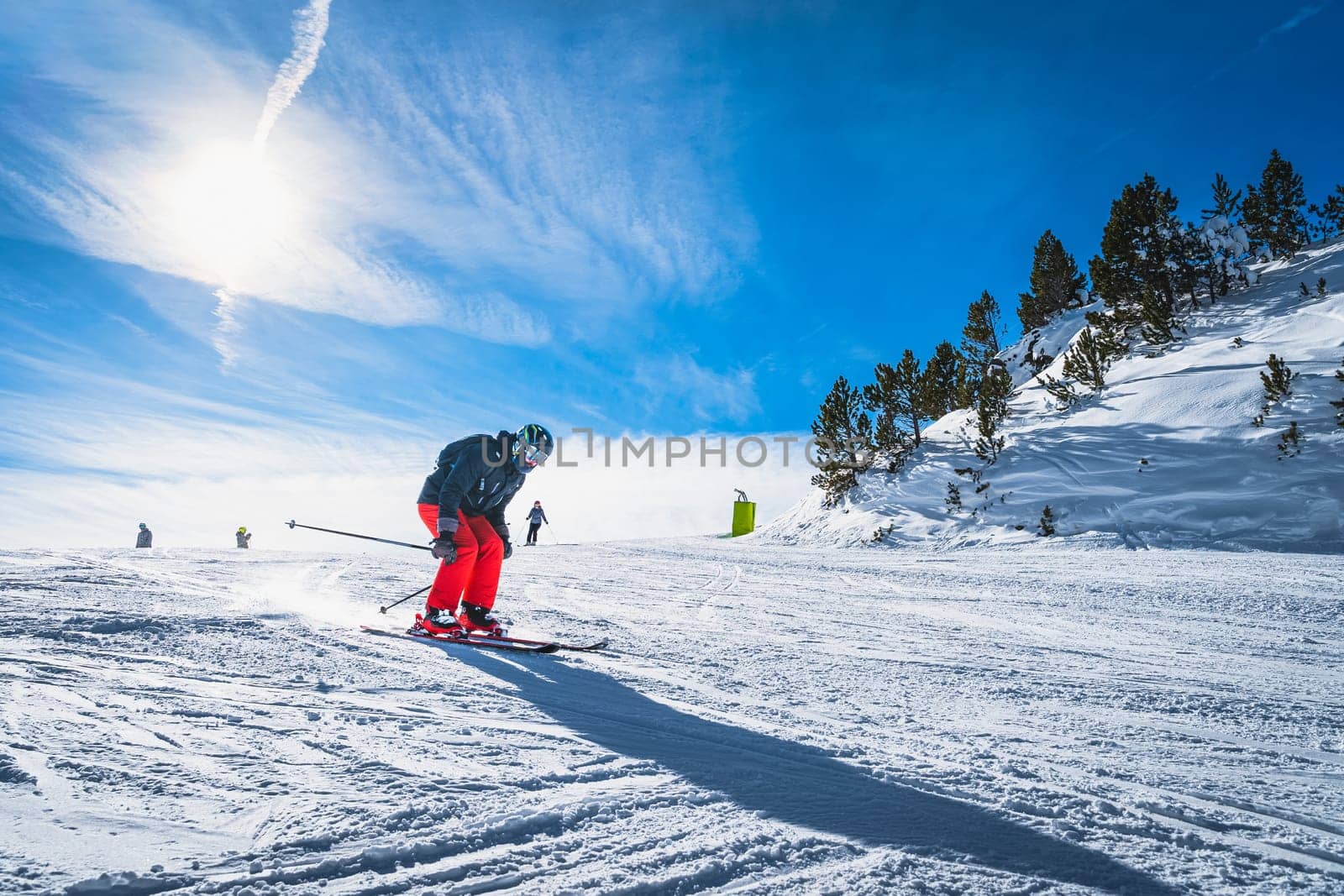 Man skiing down the ski slope or piste in Pyrenees Mountains. Winter ski holidays in El Tarter, Grandvalira, Andorra
