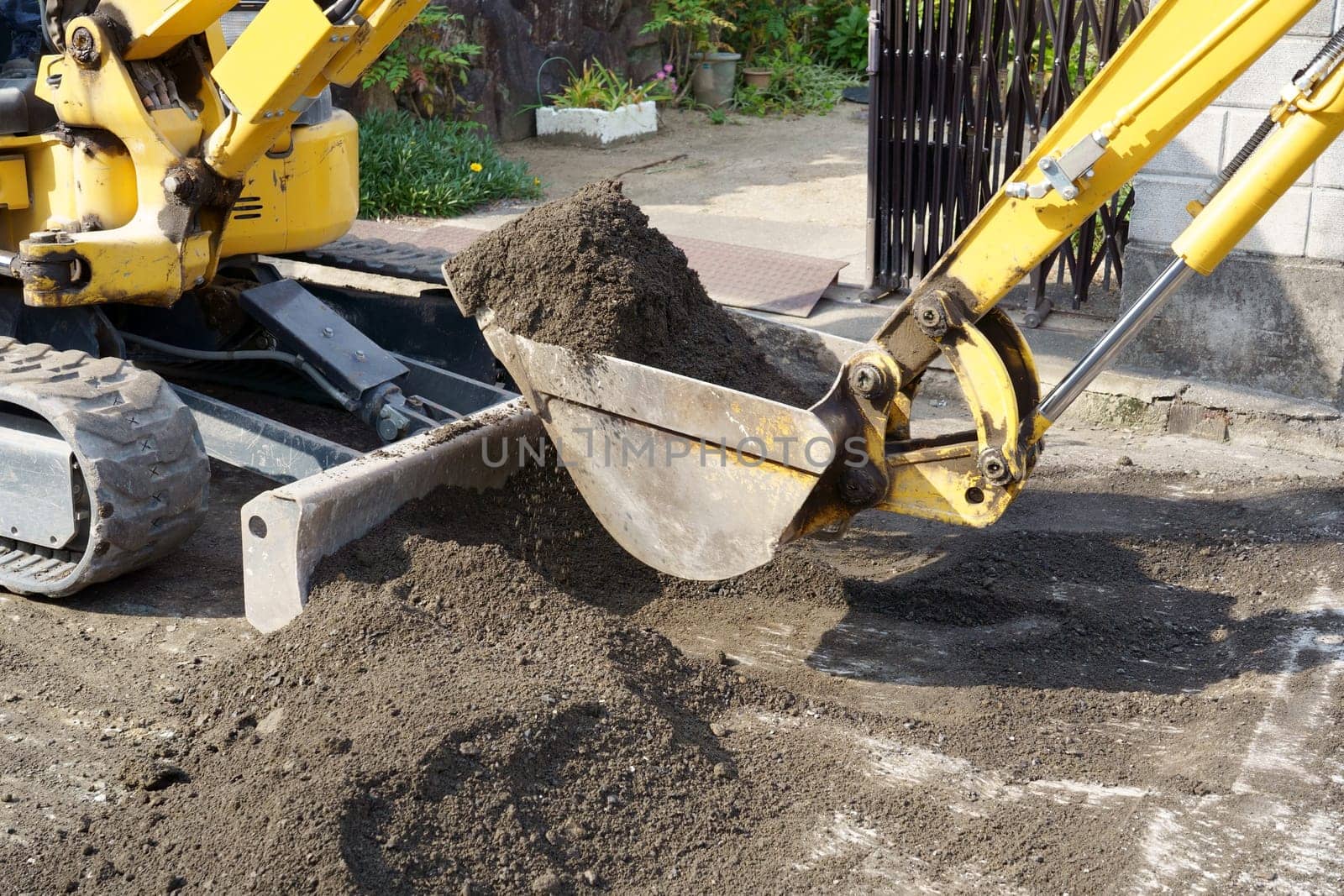 Repaving the road, The excavator is leveling gravel on the road, making a base for laying the asphalt.