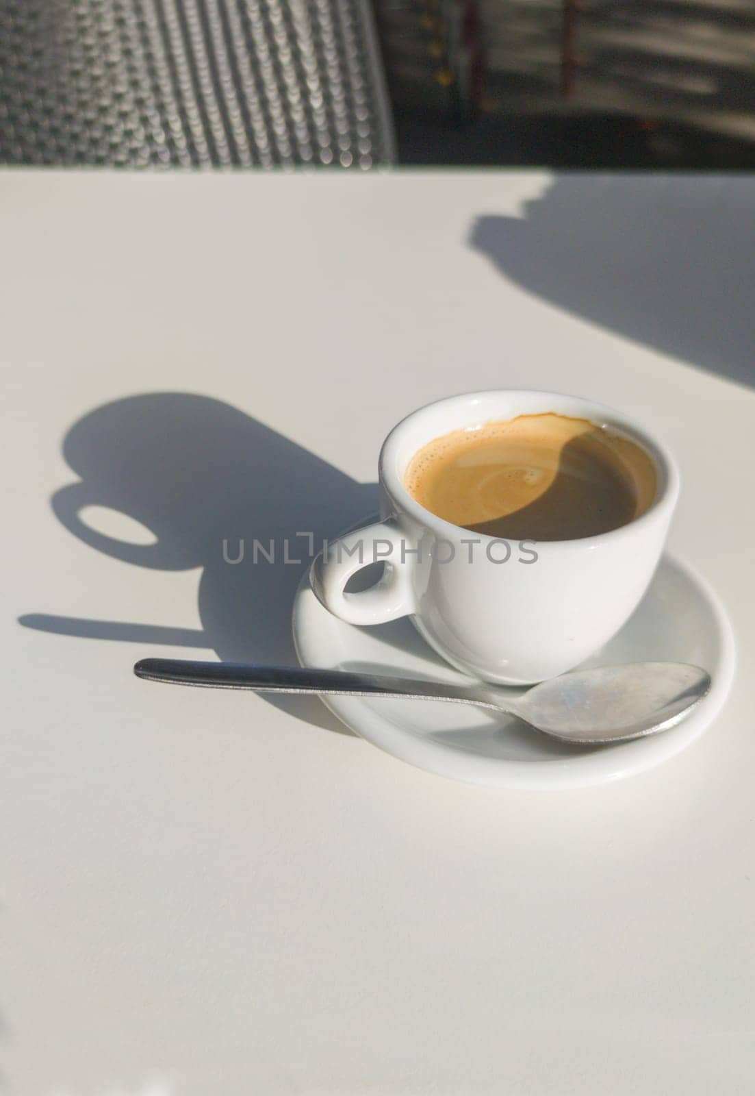 Coffee cup over terrace table a sunny day. Overhead view
